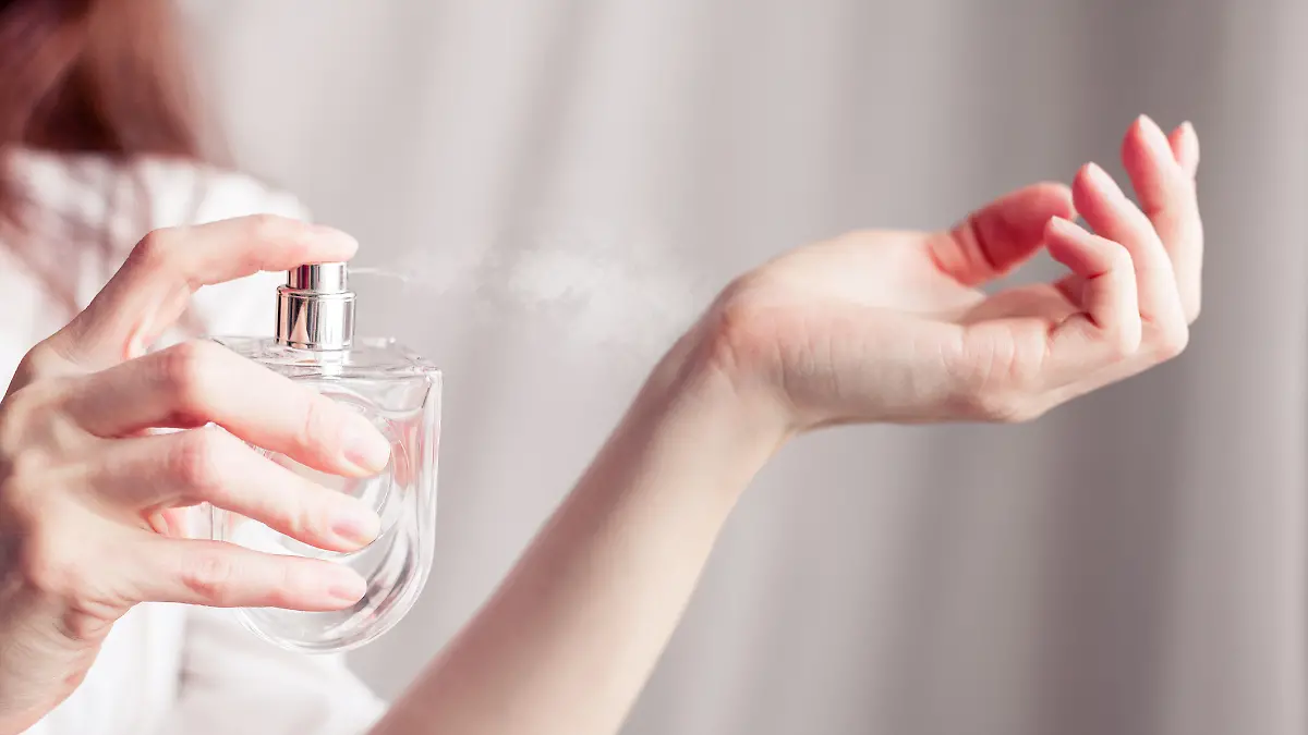 Frau sprüht Parfum