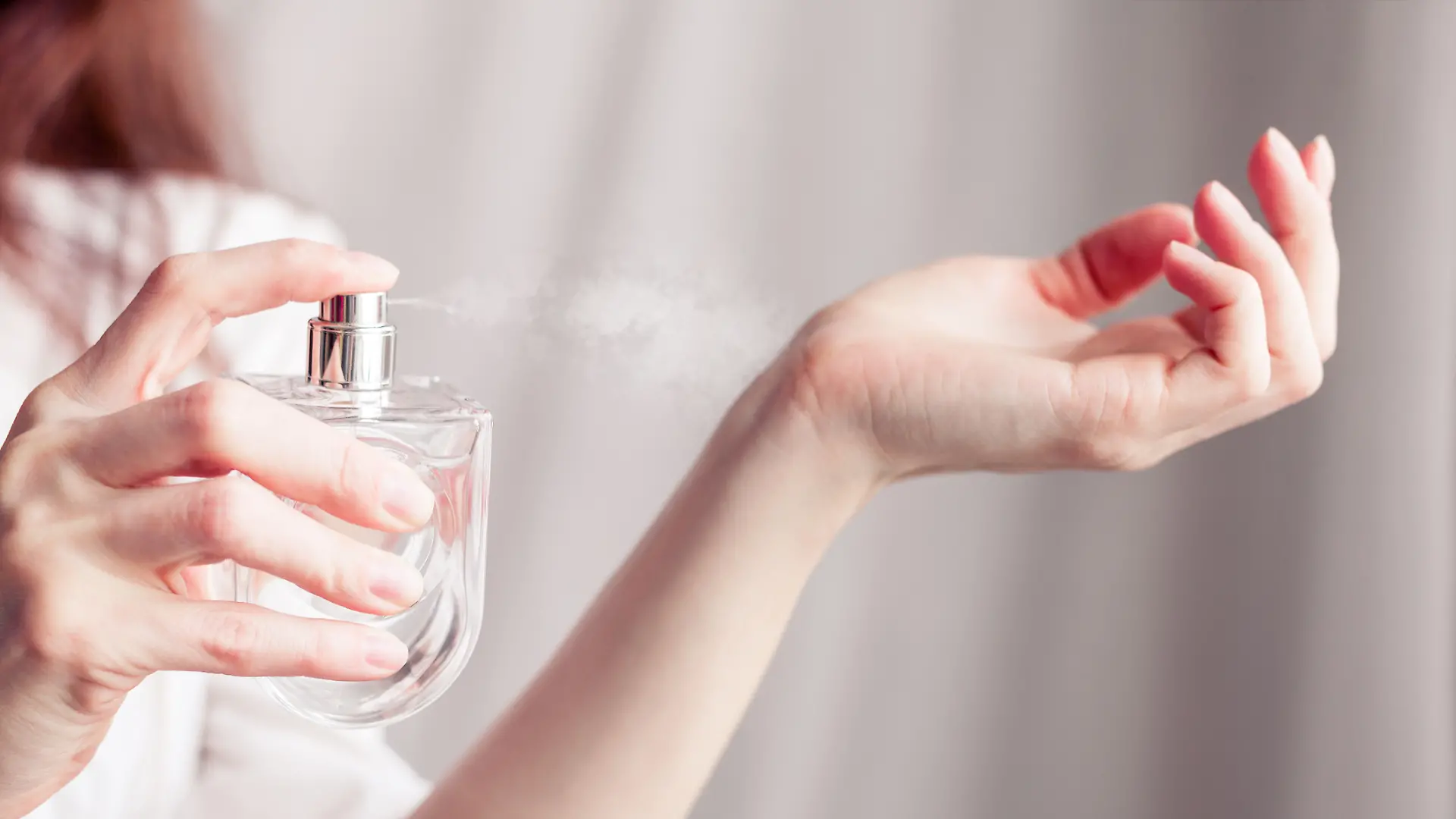 Frau sprüht Parfum