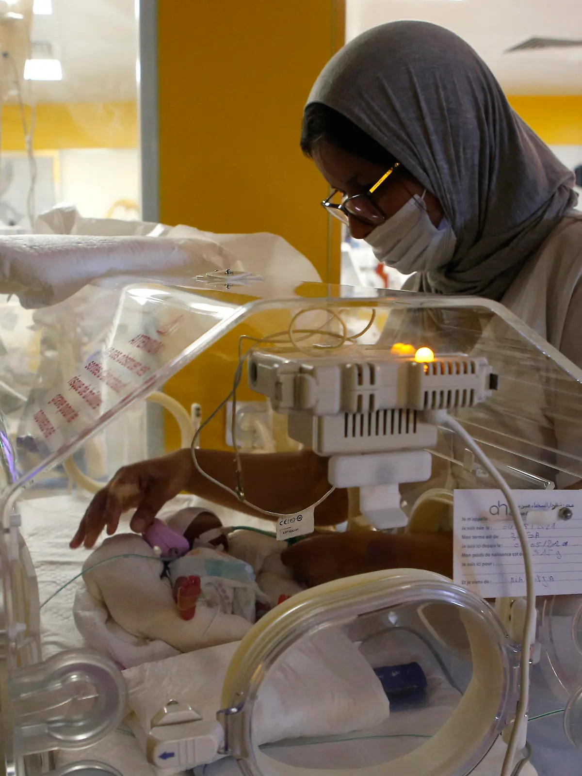 05.05.2021, Marokko, Casablanca: Eine Krankenschwester kümmert sich an einem Inkubator auf der Entbindungsstation der Privatklinik von Ain Borja um eines der neun Kinder, die eine Frau aus Mali Behördenangaben zufolge per Kaiserschnitt zur Welt gebracht hat. Foto: Abdeljalil Bounhar/AP/dpa +++ dpa-Bildfunk +++