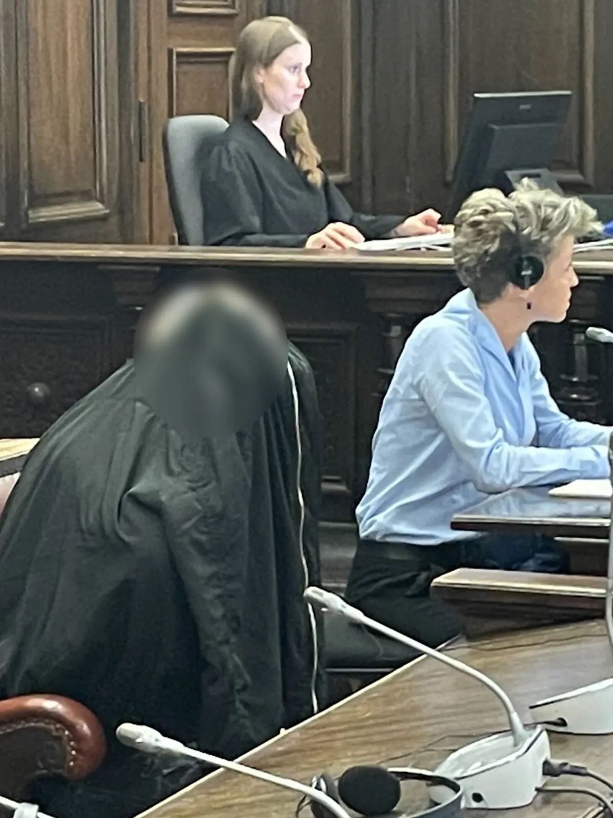 Zum Prozessauftakt versteckt sich der Angeklagte hinter einer Jacke.