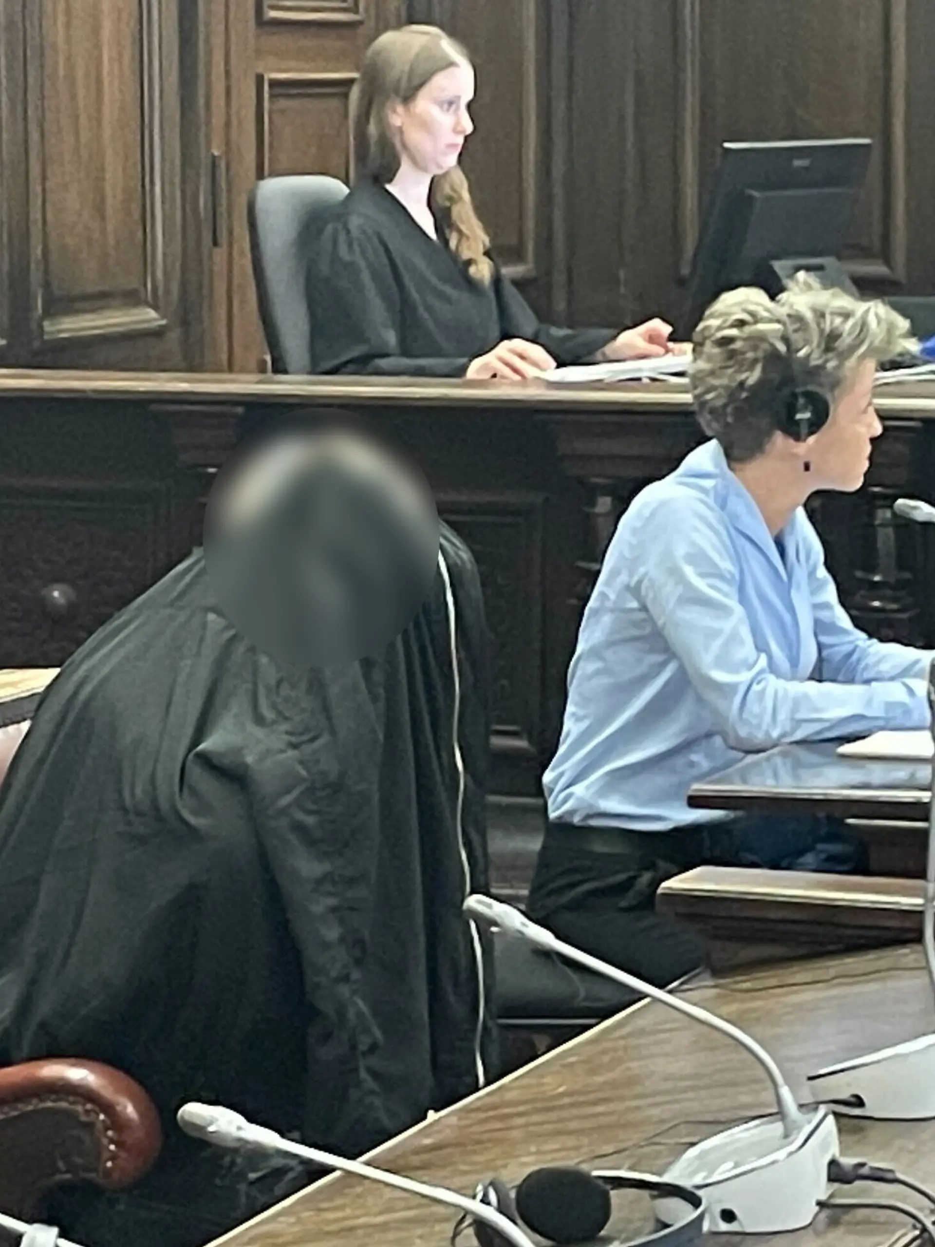 Zum Prozessauftakt versteckt sich der Angeklagte hinter einer Jacke.