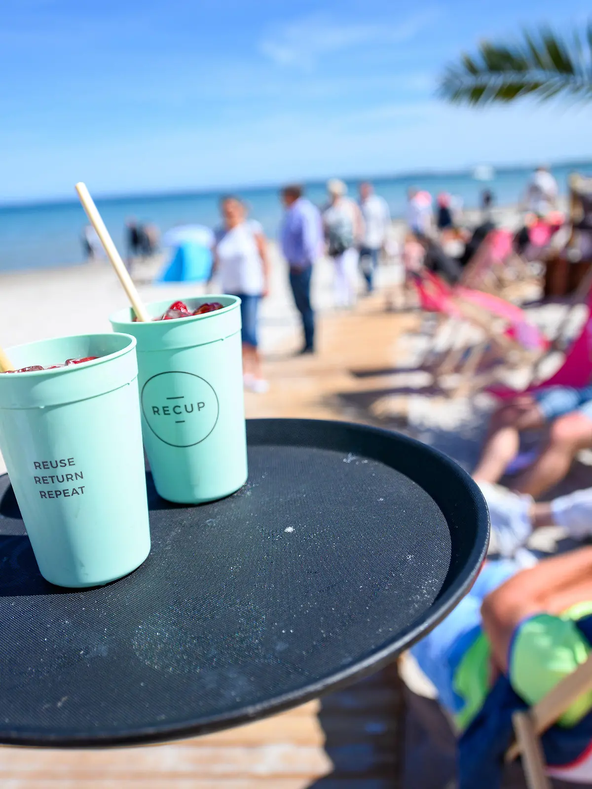 PRODUKTION - 29.05.2023, Schleswig-Holstein, Scharbeutz: Getränke stehen auf dem Tablett einer Kellnerin der Beachlounge Scharbeutz am Ostseestrand. Seit einigen Jahren breitet sich an den Ostseestränden ein neuer Trend aus. Strandbars bieten ihren Gästen kühle Getränke, bunte Cocktails und leckere Speisen an. Und ein unbeschwertes Urlaubsgefühl mit den Füßen im Sand. Foto: Jonas Walzberg/dpa +++ dpa-Bildfunk +++