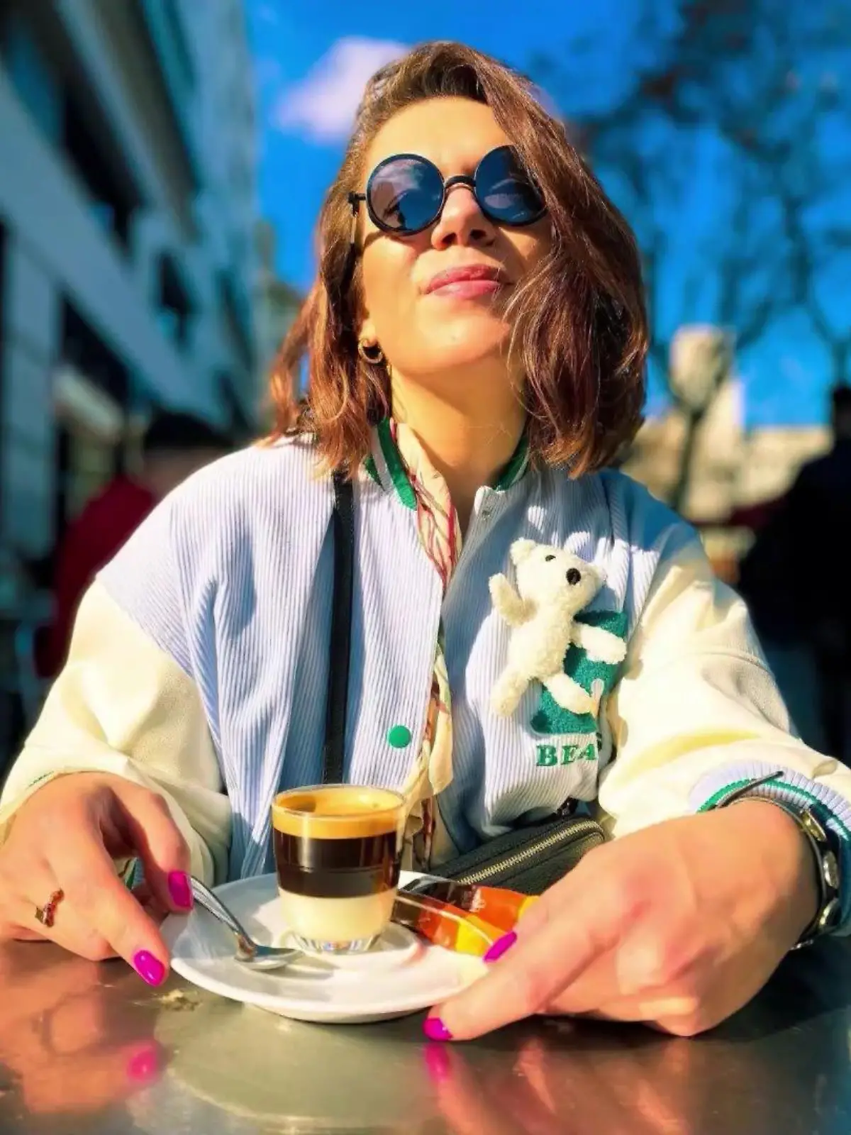 Frau mit Café Bombón vor sich