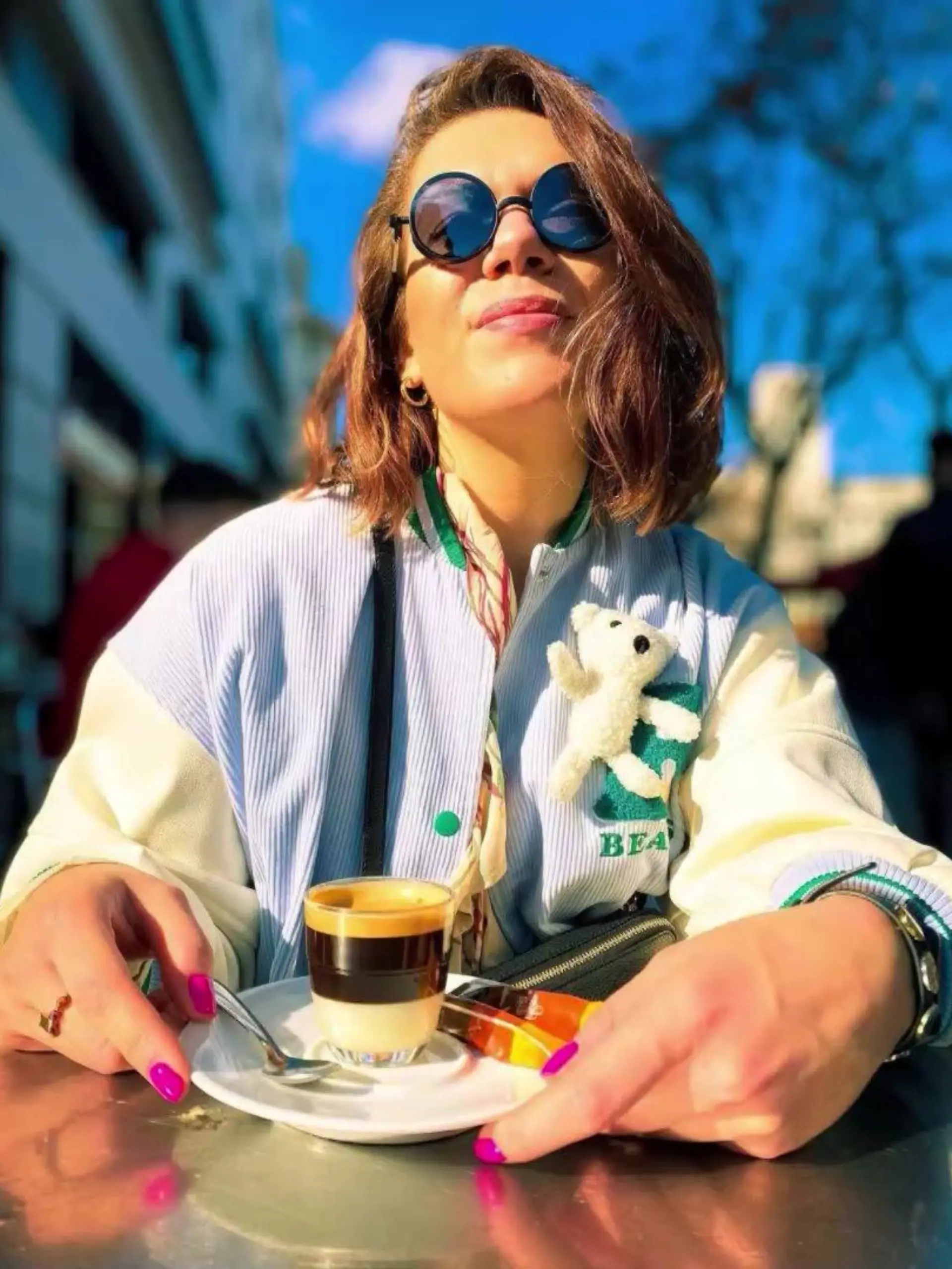Frau mit Café Bombón vor sich