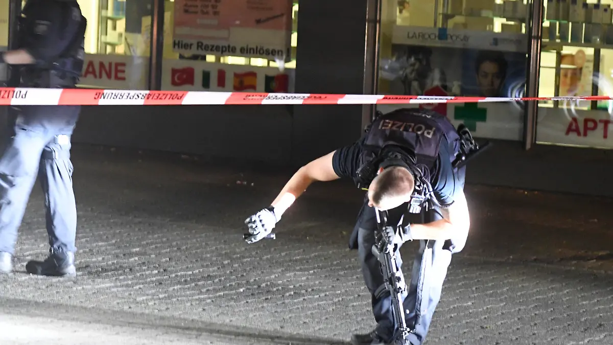 04.05.2022, Nordrhein-Westfalen, Duisburg: Polizisten suchen in der Nacht nach Spuren der Schiesserei auf dem Hamborner Altmarkt in Marxloh. Bei einer Auseinandersetzung mit Schusswaffen sind am Mittwochabend in Duisburg vier Personen verletzt worden. Foto: Roberto Pfeil/dpa +++ dpa-Bildfunk +++