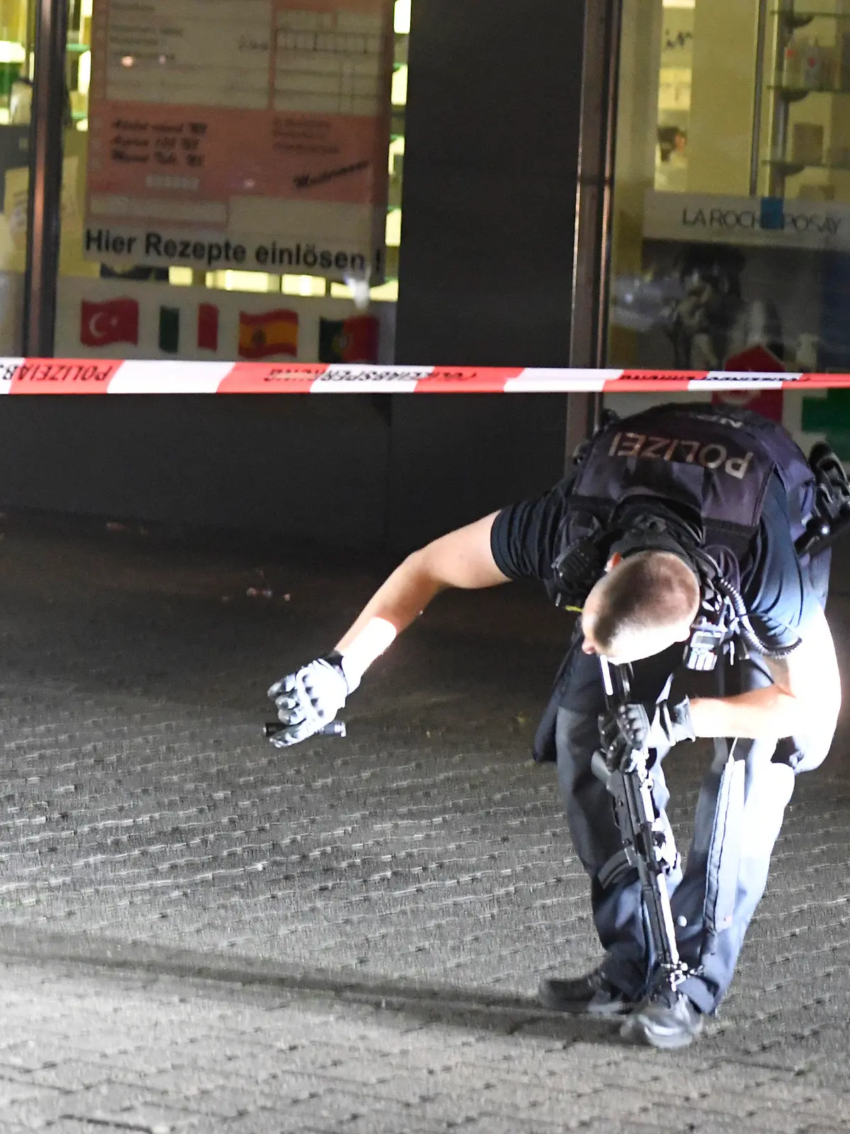 04.05.2022, Nordrhein-Westfalen, Duisburg: Polizisten suchen in der Nacht nach Spuren der Schiesserei auf dem Hamborner Altmarkt in Marxloh. Bei einer Auseinandersetzung mit Schusswaffen sind am Mittwochabend in Duisburg vier Personen verletzt worden. Foto: Roberto Pfeil/dpa +++ dpa-Bildfunk +++