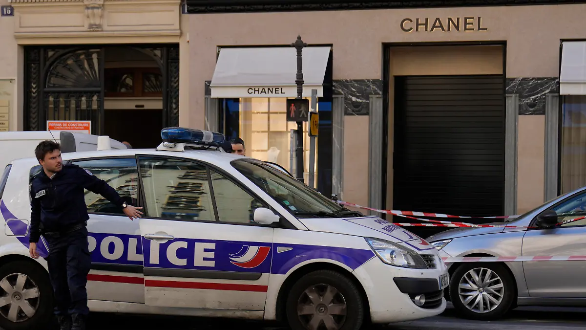 A police officer leaves his car after a hold-up in a Chanel boutique,Thursday, May 5, 2022 in Paris. No details were immediately available about what was stolen in the luxury fashion house shop by four helmeted persons who fled with a scooter and a motorcycle. (AP Photo/Francois Mori)