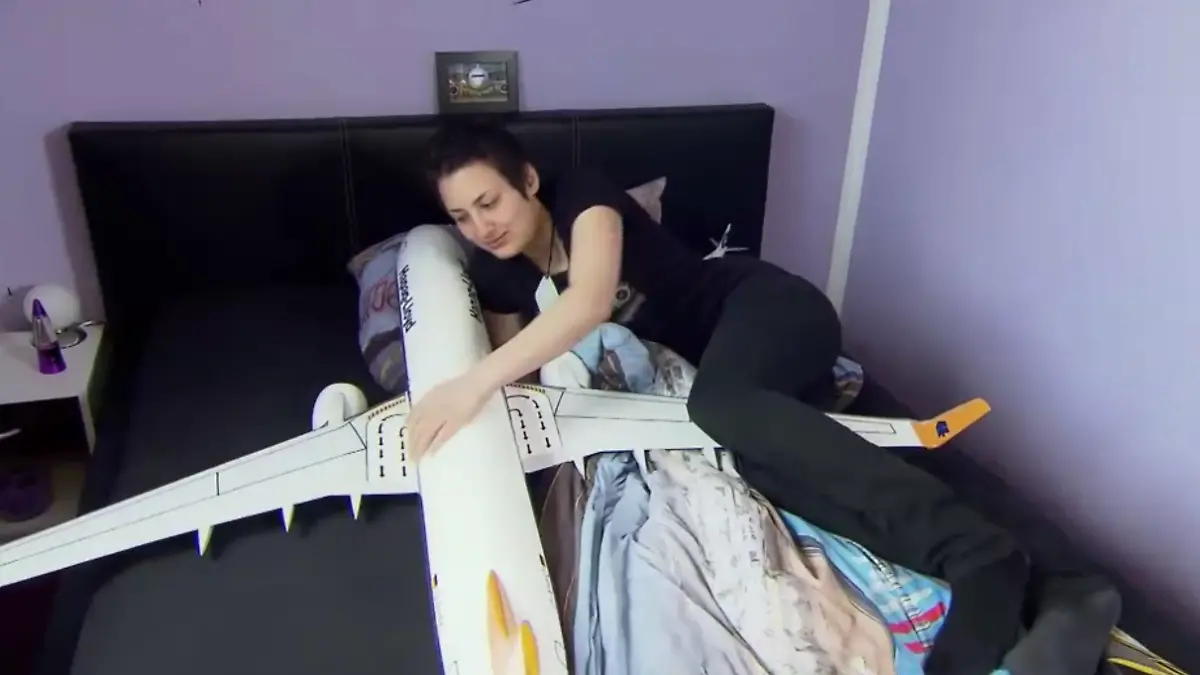 Eine Frau mit einem Flugzeugmodell im Bett.