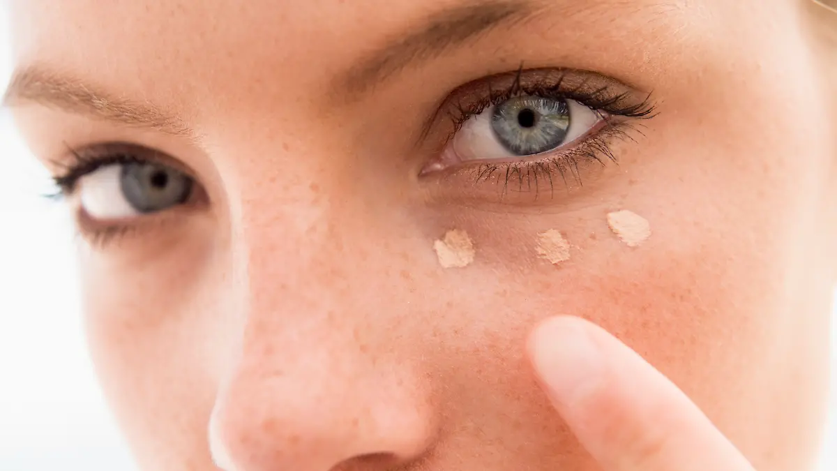 Frau trägt Concealer auf