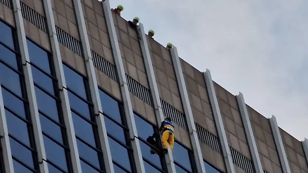 03.05.2022, Hessen, Frankfurt/Main: Ein Mann klettert ungesichert an der Fassade des Frankfurter Hochhauses «FBC» hinauf. Den Beamten zufolge handelt es sich offenbar um eine Protestaktion gegen den Krieg in der Ukraine. Der Kletterer war in blau und gelb, also in den Farben der ukrainischen Nationalflagge, gekleidet und trug einen Schriftzug mit «Stop the War» (auf Deutsch: «Stoppt den Krieg»). Foto: ---/5Vision Media/dpa +++ dpa-Bildfunk +++