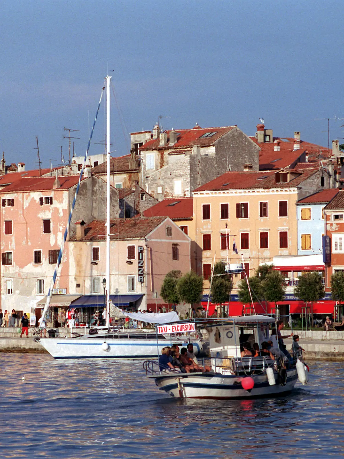 Rovinj (Kroatien): Kleine Boote liegen an der Kaimauer  vor der historischen Kulisse der Stadt Rovinj (Istrien), aufgenommen im August 2003. Die über 1000 Jahre alte Stadt mit dem Charme einer italienischen Hafenstadt wird auch Perle der Istrischen Halbinsel genannt.  (BRL470-150903)
