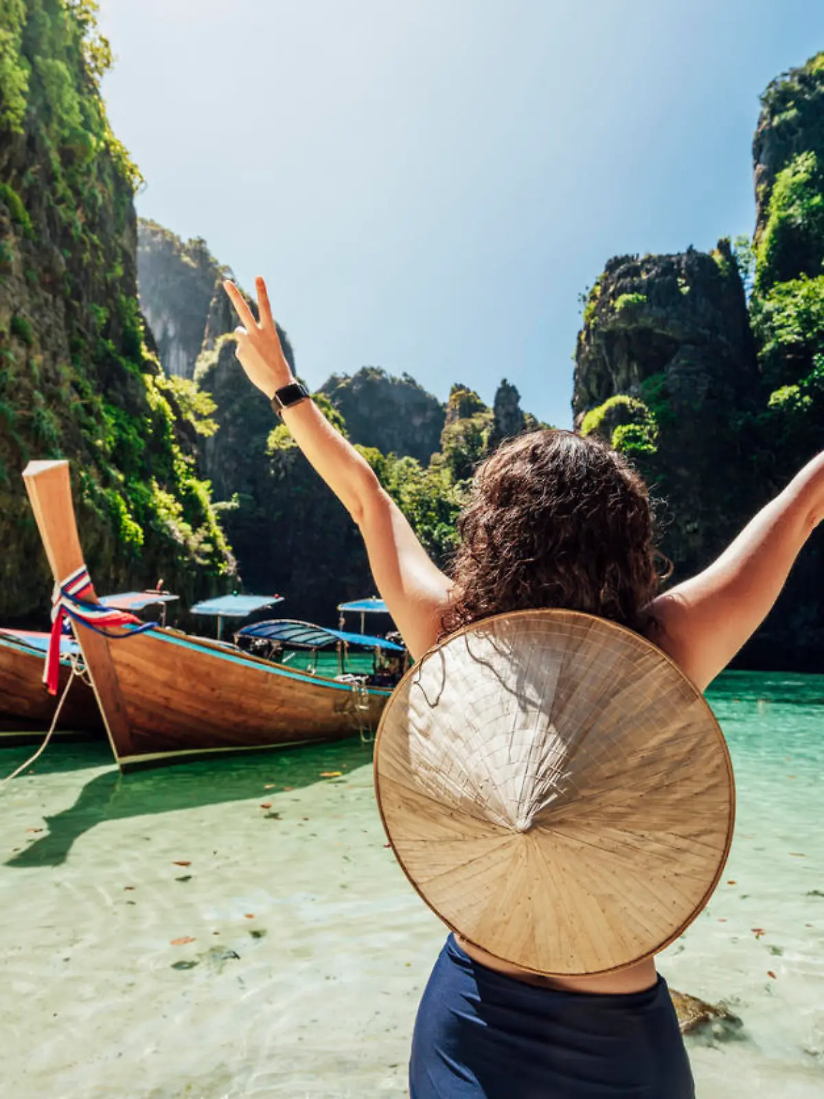 Young woman on a beautiful beach in Thailand with longtail boats, Phi Phi Island