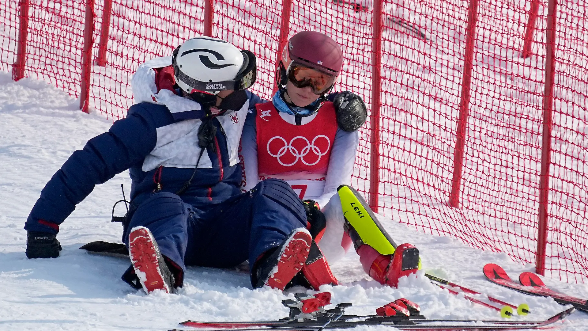 A team member consoles Mikaela Shiffrin, of the United States after she skied out in the first run of the women's slalom at the 2022 Winter Olympics, Wednesday, Feb. 9, 2022, in the Yanqing district of Beijing. (AP Photo/Robert F. Bukaty)