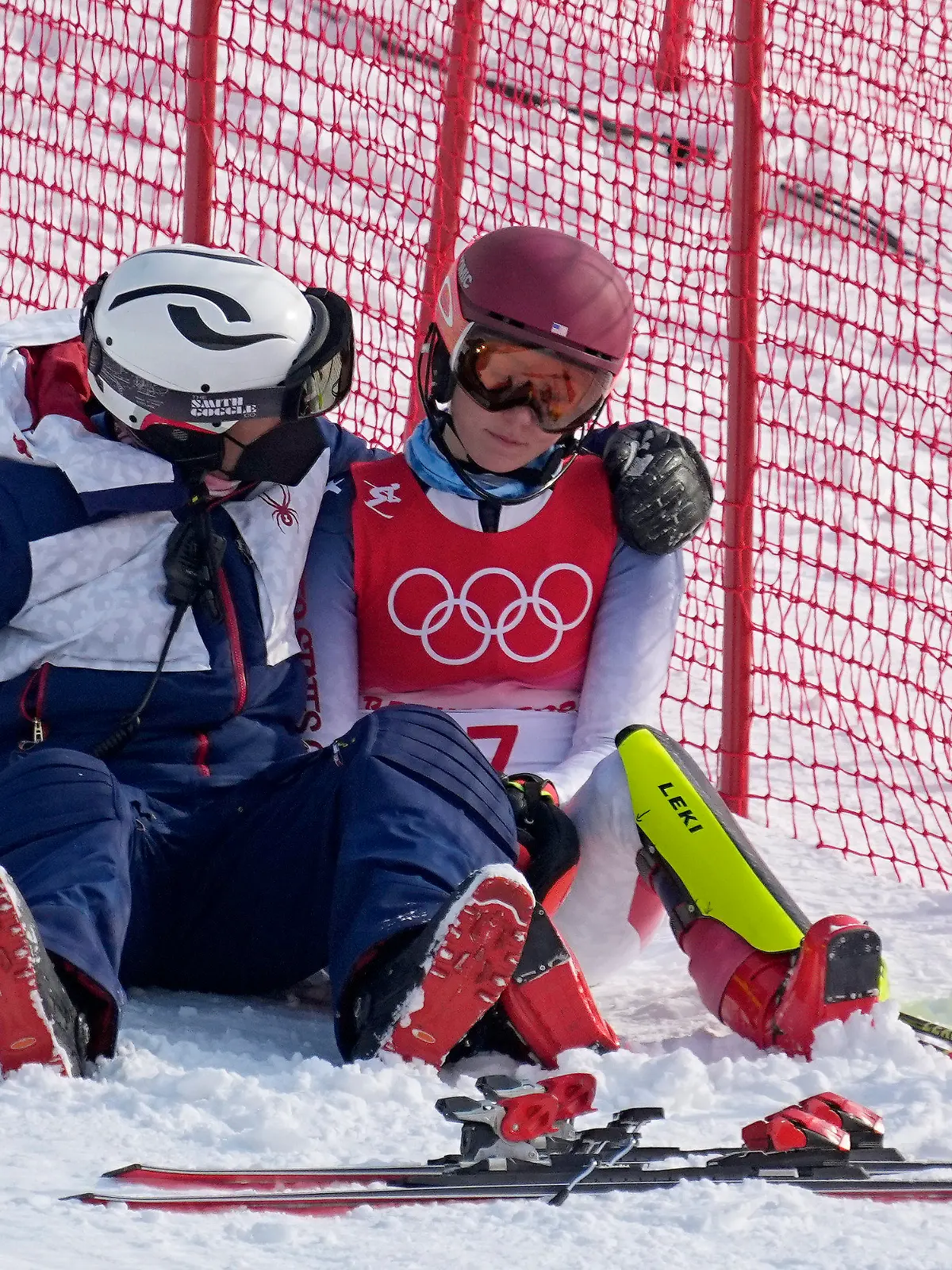 A team member consoles Mikaela Shiffrin, of the United States after she skied out in the first run of the women's slalom at the 2022 Winter Olympics, Wednesday, Feb. 9, 2022, in the Yanqing district of Beijing. (AP Photo/Robert F. Bukaty)