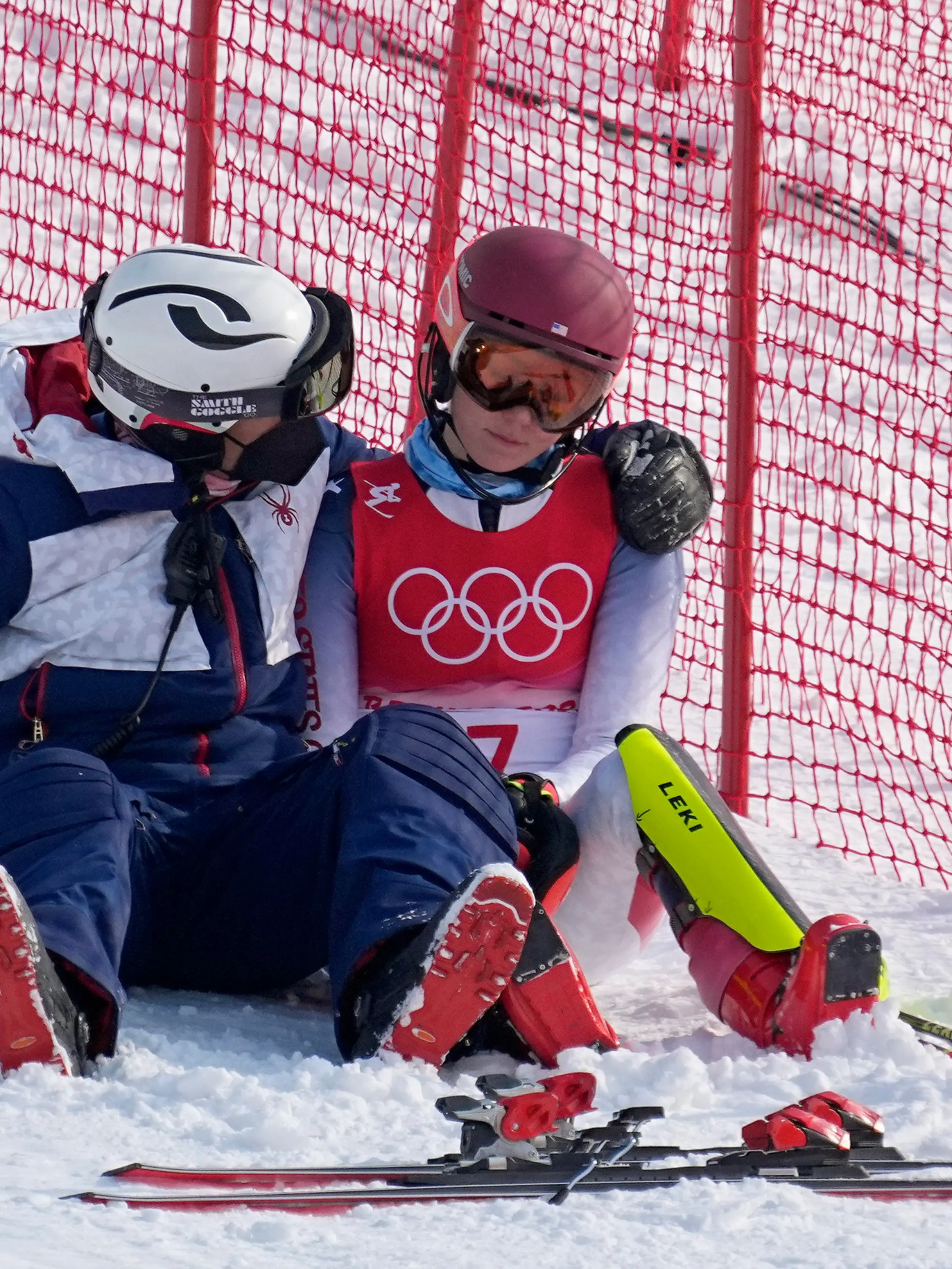A team member consoles Mikaela Shiffrin, of the United States after she skied out in the first run of the women's slalom at the 2022 Winter Olympics, Wednesday, Feb. 9, 2022, in the Yanqing district of Beijing. (AP Photo/Robert F. Bukaty)