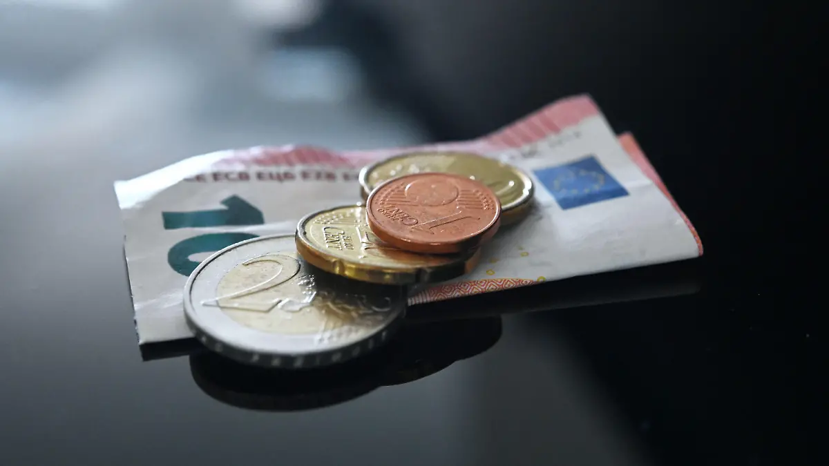 26.06.2023, Baden-Württemberg, Stuttgart: ILLUSTRATION - Münzen und ein Geldschein im Wert von 12,41 Euro liegen auf einer schwarzen Fläche (gestellte Szene). Der allgemeine gesetzliche Mindestlohn in Deutschland soll zum 1. Januar 2024 von 12,00 auf 12,41 Euro und zum 1. Januar 2025 auf 12,82 Euro steigen. Diesen Vorschlag legte die zuständige Mindestlohnkommission heute in Berlin vor. Foto: Marijan Murat/dpa +++ dpa-Bildfunk +++
