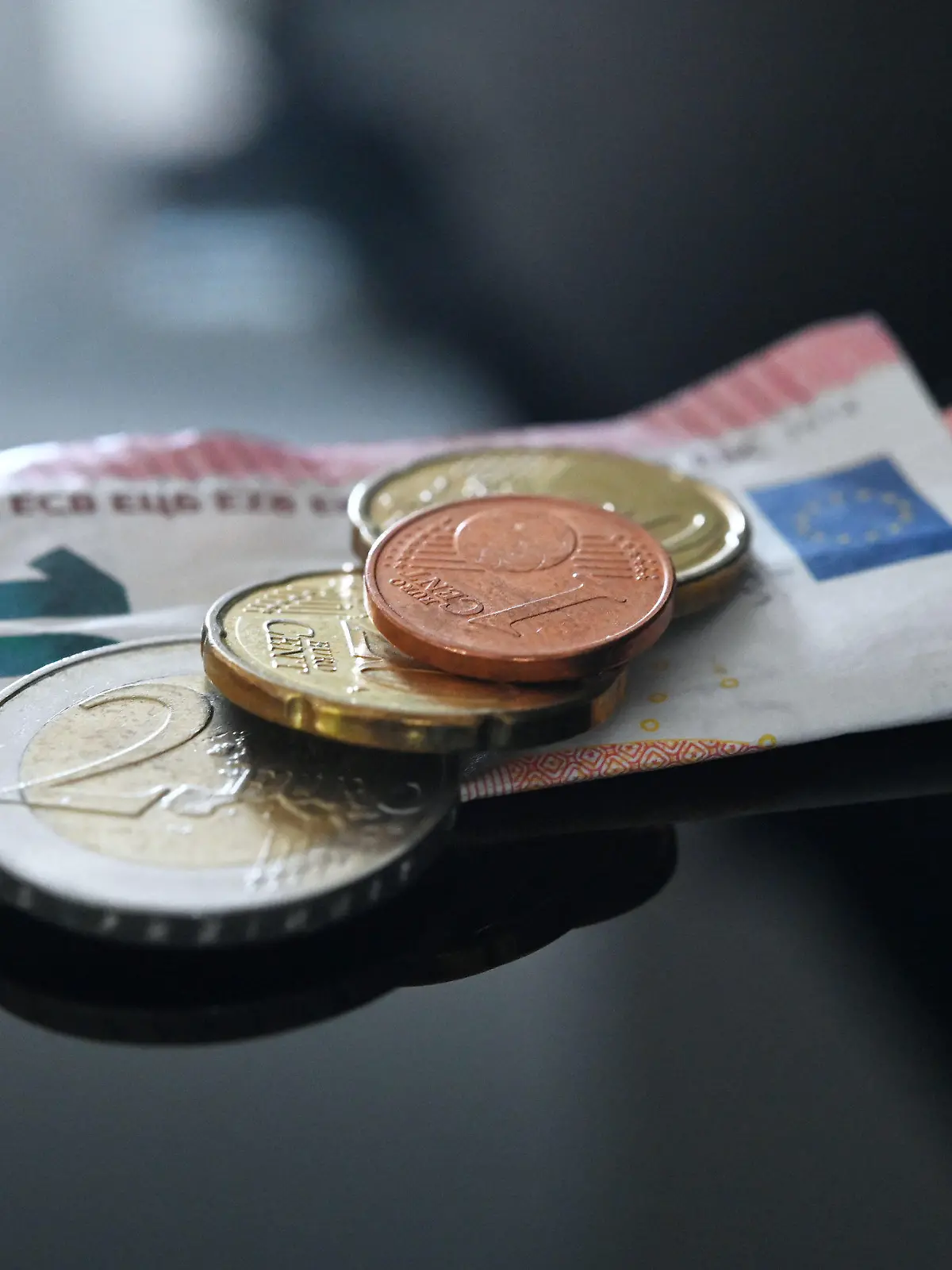 26.06.2023, Baden-Württemberg, Stuttgart: ILLUSTRATION - Münzen und ein Geldschein im Wert von 12,41 Euro liegen auf einer schwarzen Fläche (gestellte Szene). Der allgemeine gesetzliche Mindestlohn in Deutschland soll zum 1. Januar 2024 von 12,00 auf 12,41 Euro und zum 1. Januar 2025 auf 12,82 Euro steigen. Diesen Vorschlag legte die zuständige Mindestlohnkommission heute in Berlin vor. Foto: Marijan Murat/dpa +++ dpa-Bildfunk +++