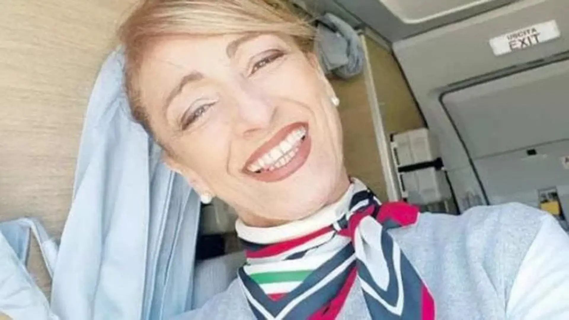 Die Stewardess steht in einem Flugzeug.