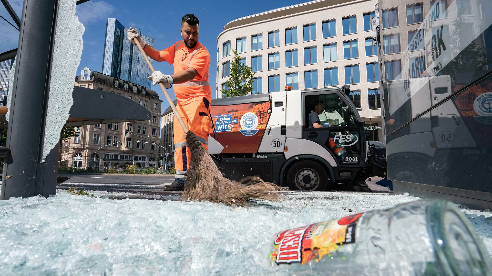 19.07.2020, Hessen, Frankfurt/Main: Mitarbeiter der Stadtreinigung beseitigen am Morgen vor der Alten Oper Scherben der zertrümmerten Scheiben einer Bushaltestelle. In der Nacht zum 19.07.2020 ist es auf dem Opernplatz zu gewalttätigen Krawallen gekommen. Wie die Polizei mitteilte, hatten rund 3000 Menschen Partys gefeiert, als die Randale ausbrachen. 39 Menschen seien daraufhin festgenommen worden, acht davon seien am Sonntagmorgen noch in Gewahrsam gewesen. Foto: Frank Rumpenhorst/dpa +++ dpa-Bildfunk +++