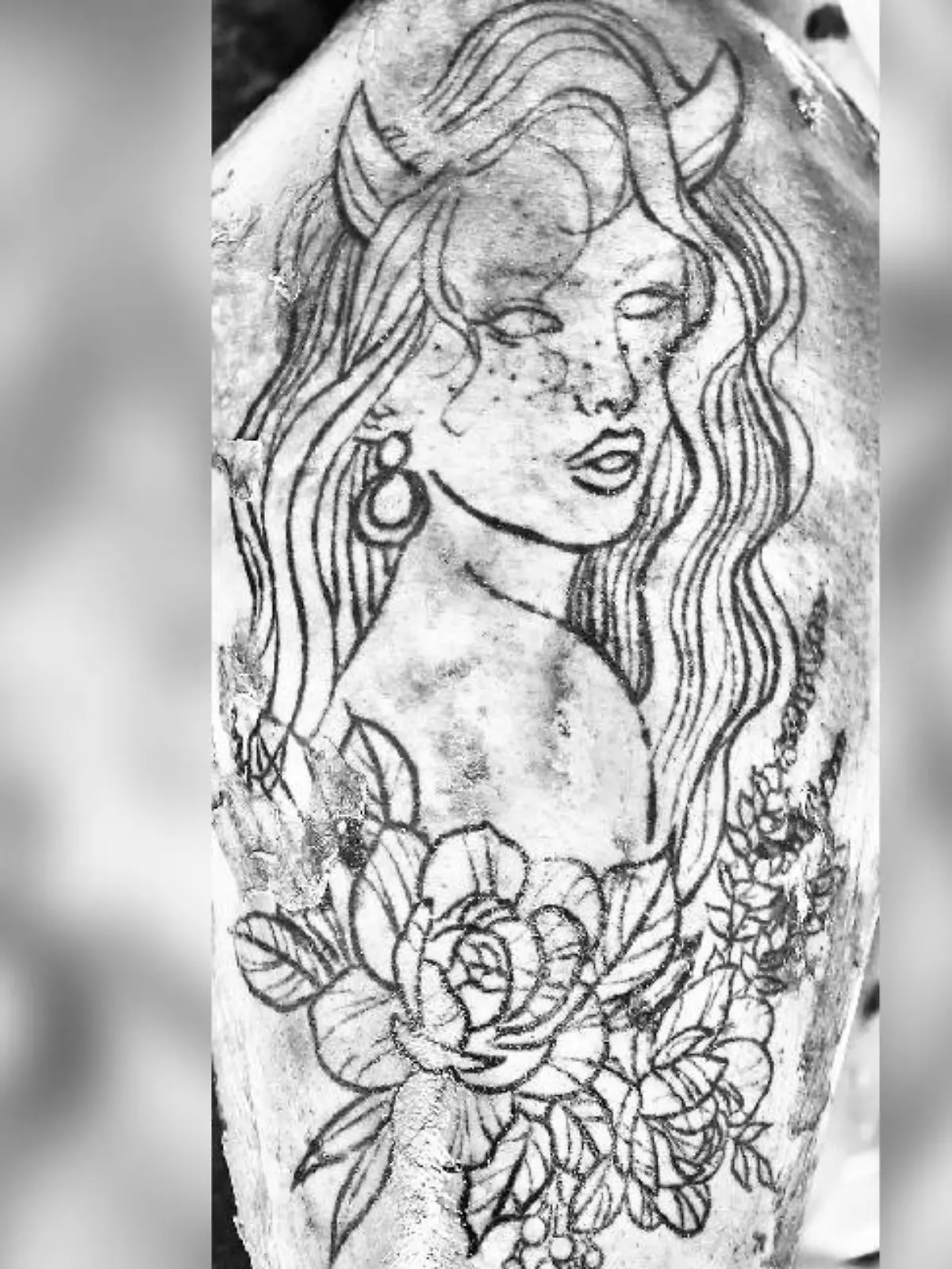 Ein Tattoo zeigt den Kopf einer Frau.