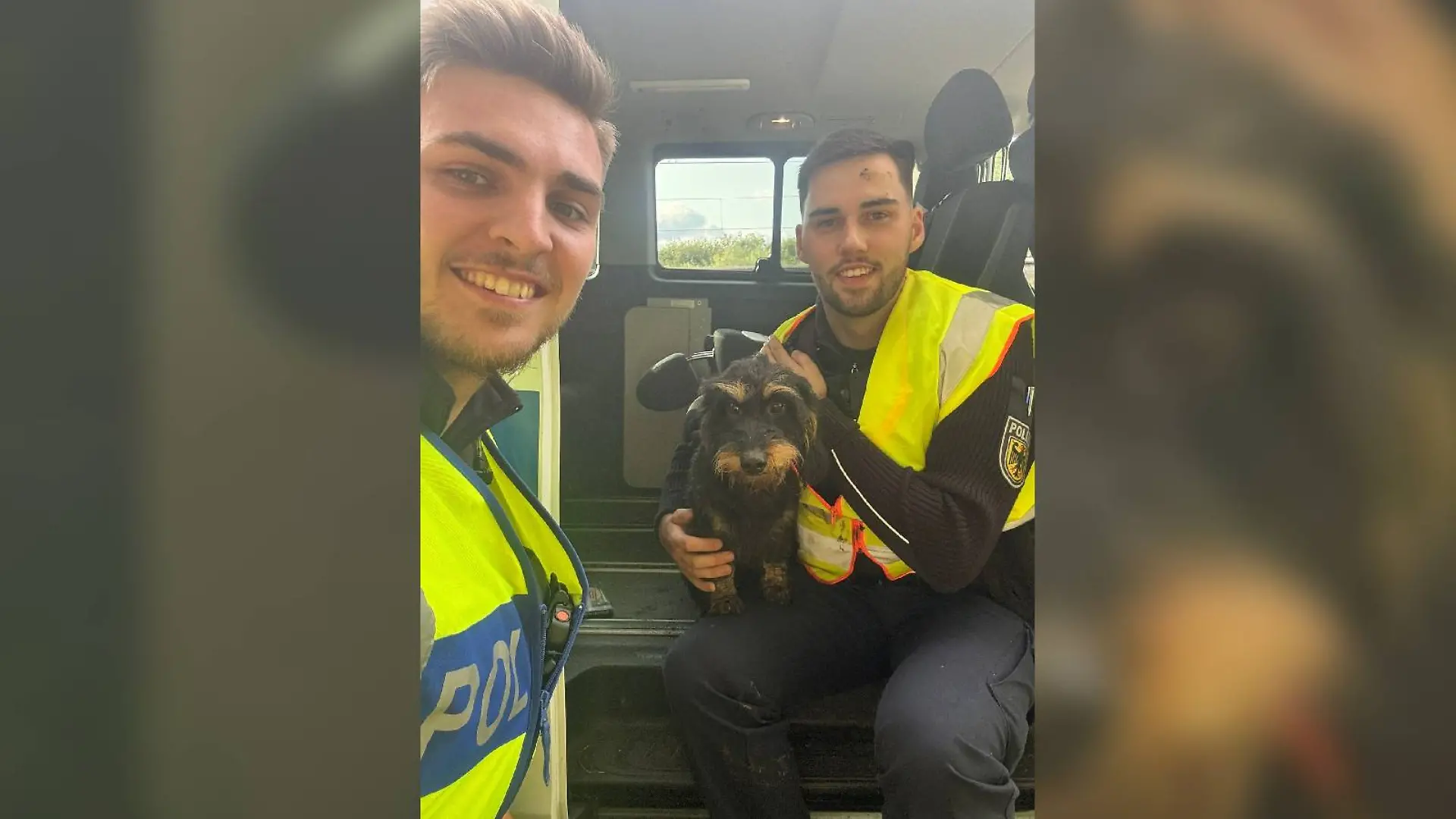 Die Bundespolizisten Marvin Schick (li) und Danny Heineke mit dem geretteten Rauhaardackel.