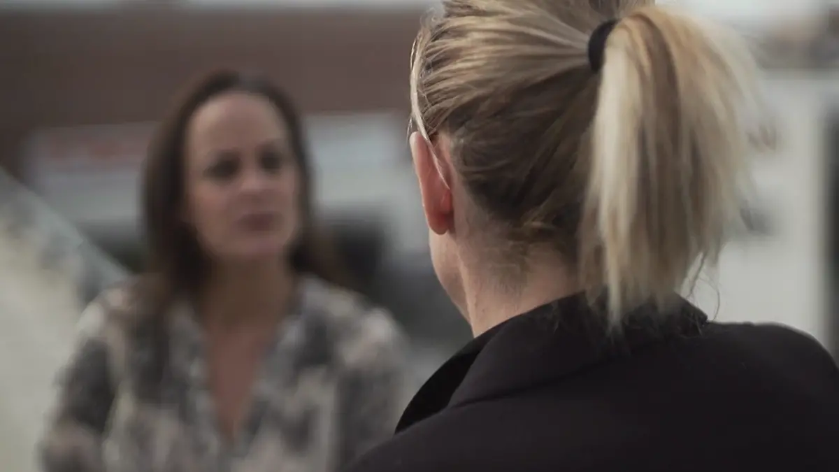 Eine Frau von hinten im Interview.