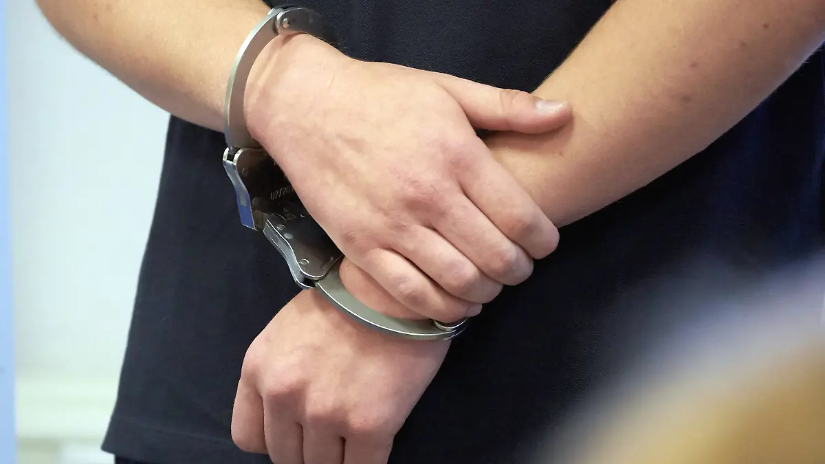 ARCHIV - 14.08.2019, Rheinland-Pfalz, Koblenz: Ein Mann trägt Handschellen in einem Gerichtssaal. Die Zahl der offenen Haftbefehle ist in Nordrhein-Westfalen seit Anfang vergangenen Jahres um fast 13 Prozent auf 27 613 gestiegen. (zu dpa: «Zahl der offenen Haftbefehle weiter gestiegen») Foto: Thomas Frey/dpa +++ dpa-Bildfunk +++