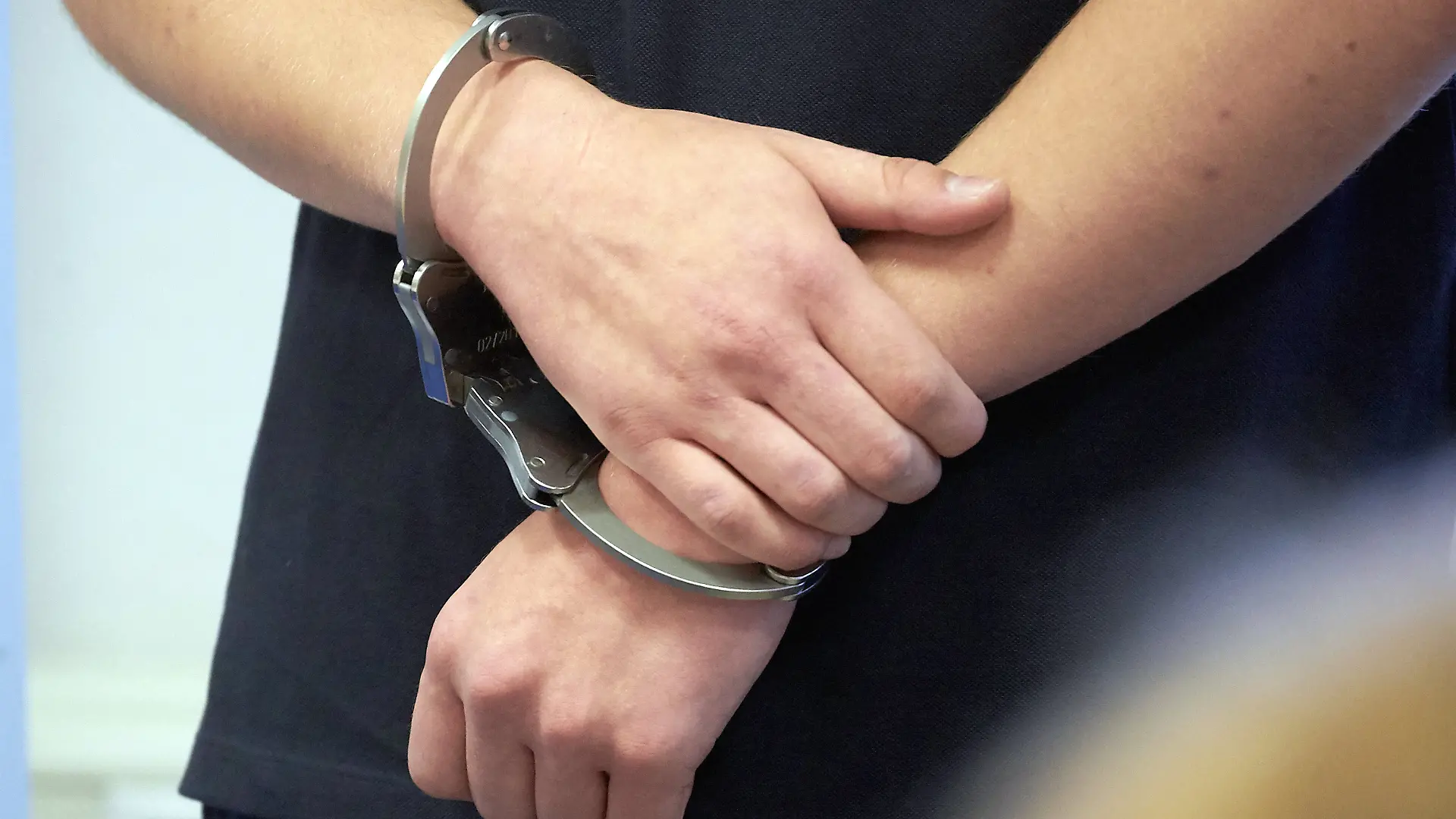 ARCHIV - 14.08.2019, Rheinland-Pfalz, Koblenz: Ein Mann trägt Handschellen in einem Gerichtssaal. Die Zahl der offenen Haftbefehle ist in Nordrhein-Westfalen seit Anfang vergangenen Jahres um fast 13 Prozent auf 27 613 gestiegen. (zu dpa: «Zahl der offenen Haftbefehle weiter gestiegen») Foto: Thomas Frey/dpa +++ dpa-Bildfunk +++