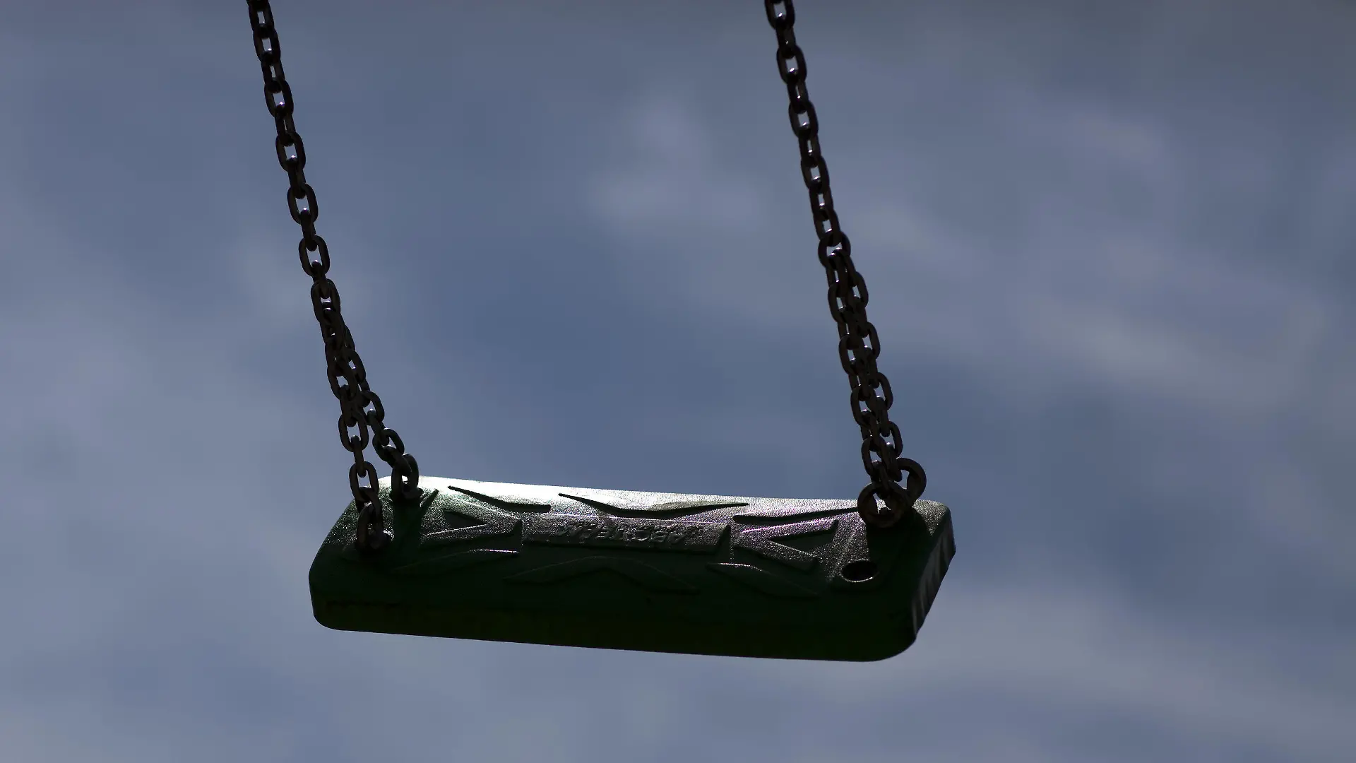 ARCHIV - 23.06.2009, Mecklenburg-Vorpommern, Rostock: Eine leere Kinderschaukel zeichnet sich auf einem Spielplatz als dunkle Silhouette vor blauem Himmel ab. (zu dpa «Kostenfaktor und Gefahr? - Vandalismus auf Kinderspielplätzen») Foto: Arno Burgi/dpa-Zentralbild/dpa +++ dpa-Bildfunk +++