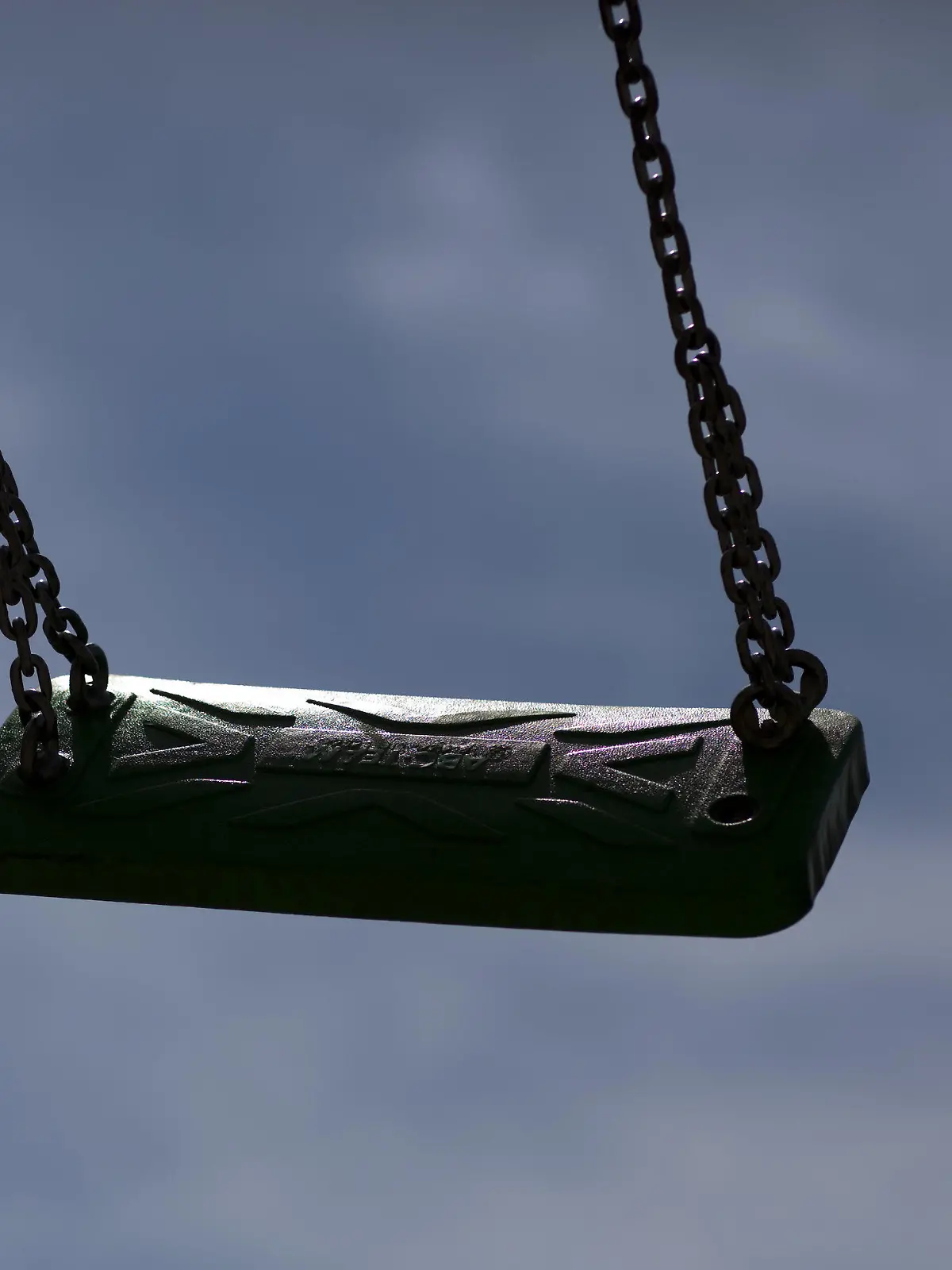 ARCHIV - 23.06.2009, Mecklenburg-Vorpommern, Rostock: Eine leere Kinderschaukel zeichnet sich auf einem Spielplatz als dunkle Silhouette vor blauem Himmel ab. (zu dpa «Kostenfaktor und Gefahr? - Vandalismus auf Kinderspielplätzen») Foto: Arno Burgi/dpa-Zentralbild/dpa +++ dpa-Bildfunk +++