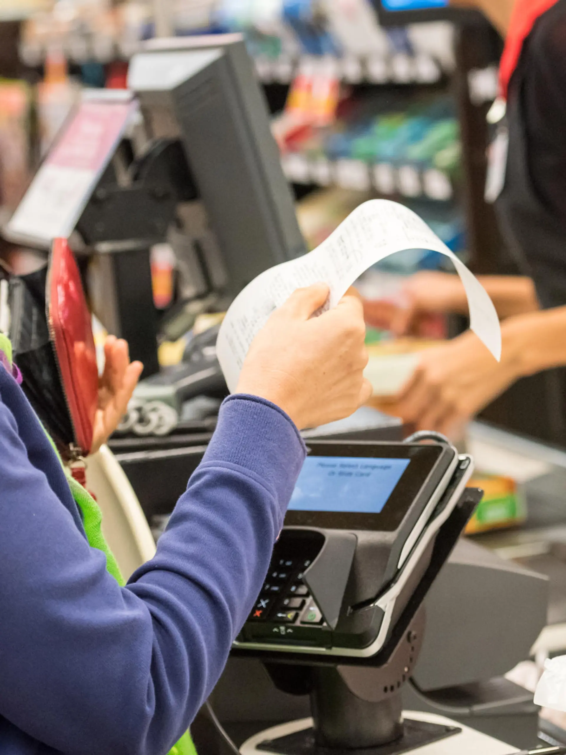 Caucasian woman electronic signing her bill at the supermarket