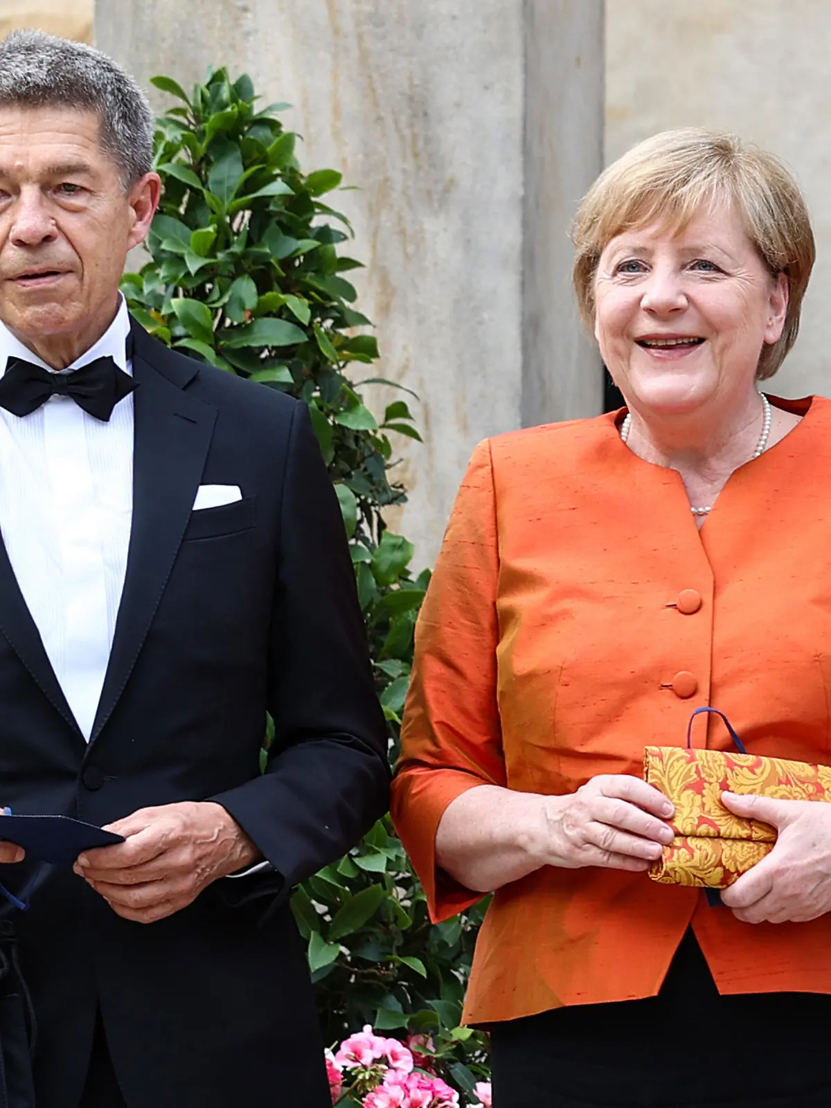 25.07.2021, Bayern, Bayreuth: Start der Richard-Wagner-Festspiele mit einer Neuinszenierung der Oper «Der fliegende Holländer». Bundeskanzlerin Angela Merkel (CDU) und ihr Mann Joachim Sauer kommen zum Festspielhaus auf dem Grünen Hügel. Foto: Daniel Karmann/dpa +++ dpa-Bildfunk +++