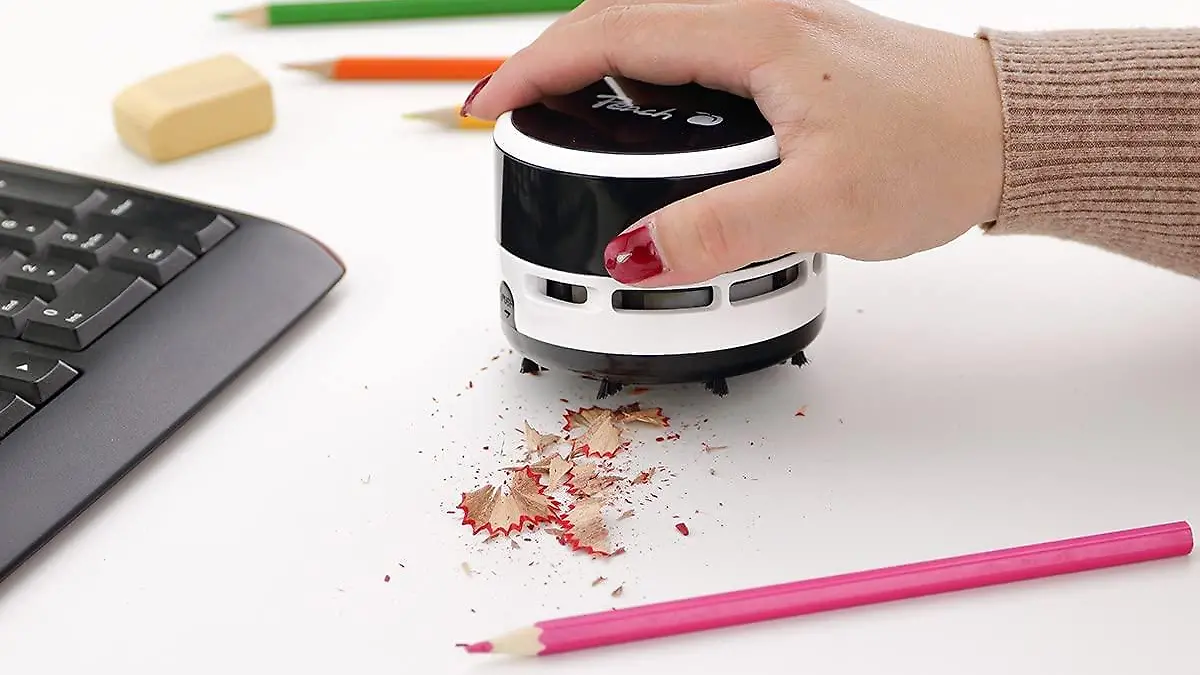Der Mini-Staubsauger von Peach saugt auf dem Schreibtisch.