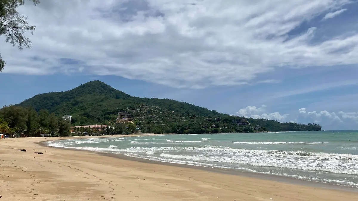 ARCHIV - 08.08.2021, Thailand, Kamala Beach: Wenige Wolken verdecken den blauen Himmel über dem Strand Kamala Beach auf Phuket. Vor einem Strand der thailändischen Urlaubsinsel Phuket ist ein achtjähriges Kind von einem Raubfisch attackiert und schwer am Bein verletzt worden. Den Rettungsdiensten zufolge könnte es sich entweder um einen großen Barrakuda oder um einen Hai gehandelt haben. (zu dpa «Achtjähriger auf Phuket von Fisch attackiert - Hai oder Barrakuda?») Foto: Carola Frentzen/dpa +++ dpa-Bildfunk +++