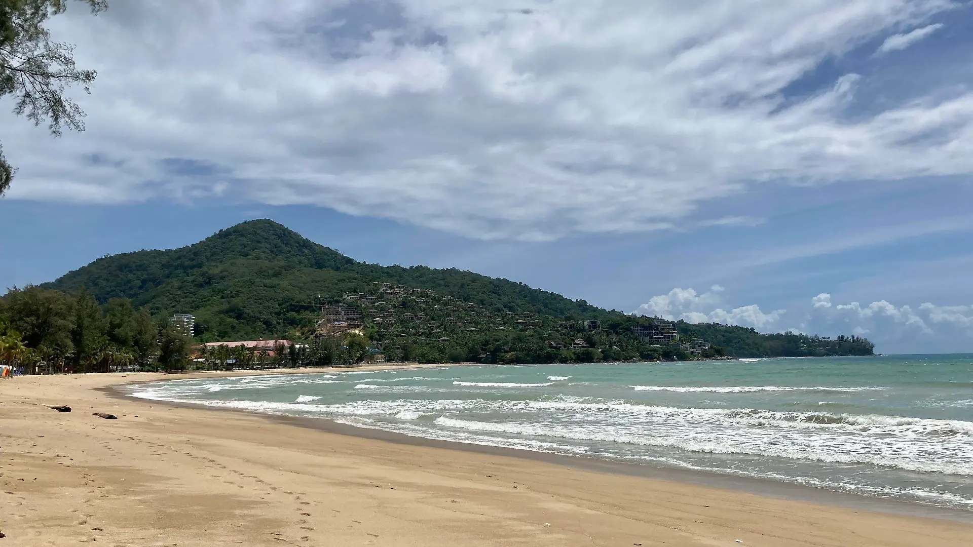 ARCHIV - 08.08.2021, Thailand, Kamala Beach: Wenige Wolken verdecken den blauen Himmel über dem Strand Kamala Beach auf Phuket. Vor einem Strand der thailändischen Urlaubsinsel Phuket ist ein achtjähriges Kind von einem Raubfisch attackiert und schwer am Bein verletzt worden. Den Rettungsdiensten zufolge könnte es sich entweder um einen großen Barrakuda oder um einen Hai gehandelt haben. (zu dpa «Achtjähriger auf Phuket von Fisch attackiert - Hai oder Barrakuda?») Foto: Carola Frentzen/dpa +++ dpa-Bildfunk +++