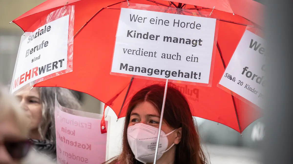 Eine Demonstrantin trägt bei einem Protestmarsch durch die Friedberger Innenstadt einen Regenschirm mit einem Plakat und der Aufschrift "Wer eine Horde Kinder managt verdient auch ein Managergehalt". Die Gewerkschaft Verdi hatte zu weiteren Warnstreiks in hessischen Kindertagesstätten sowie in der Sozialarbeit und der Behindertenhilfe aufgerufen. Hintergrund des Tarifkonflikts sind die laufenden Verhandlungen für die bundesweit rund 330 000 Kita-Erzieherinnen und -Erzieher sowie von Angehörigen anderer sozialer Berufe im kommunalen Bereich.