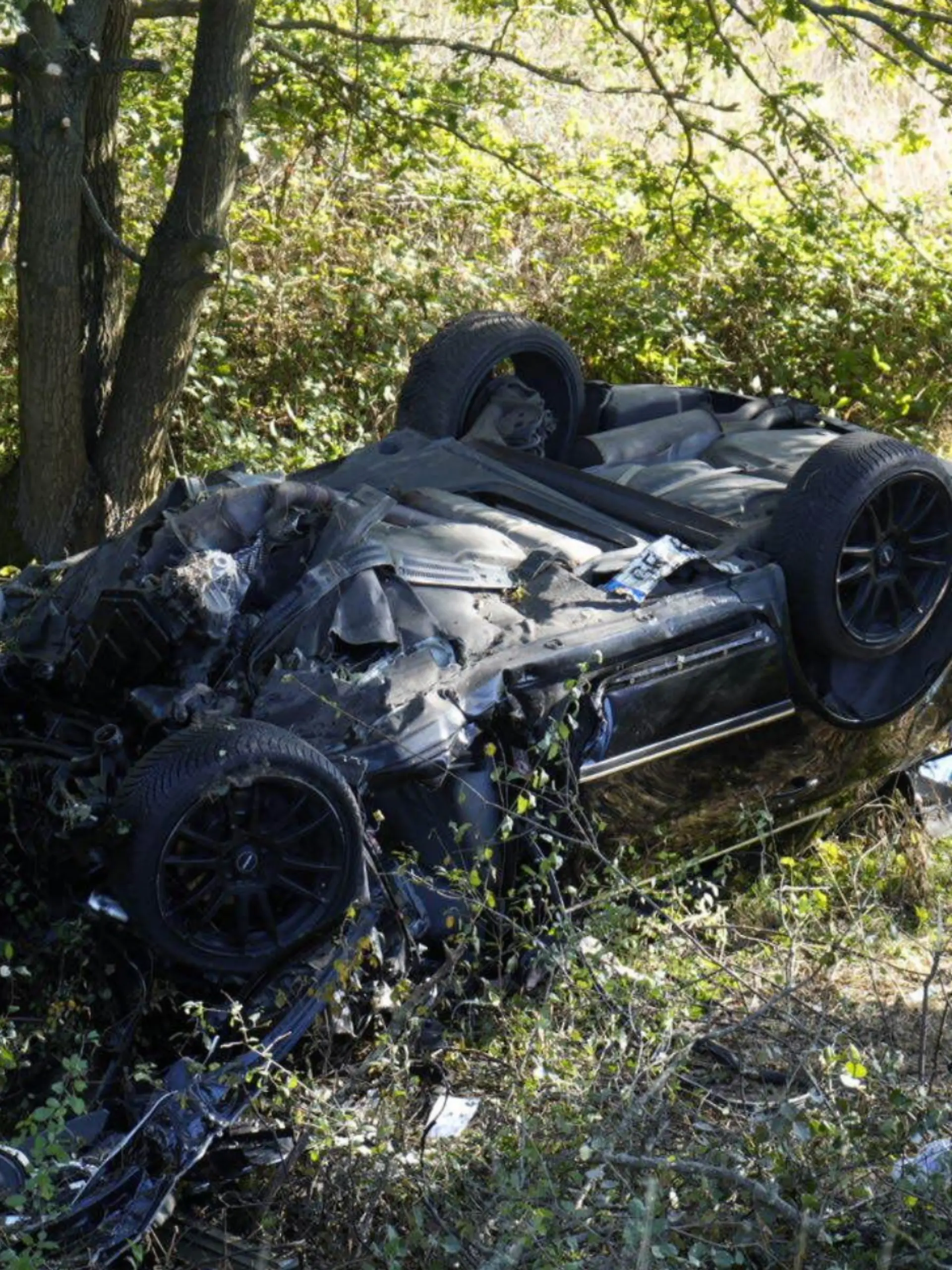 Ein Autowrack in einer Böschung. 