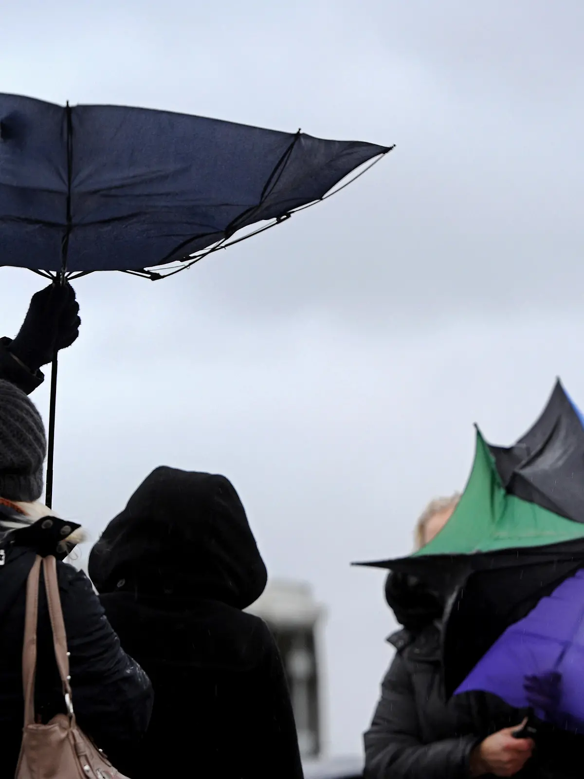 dpatopbilder - Mit strapazierten Regenschirmen kämpfen zwei Besucherinnen am 12.12.2014 auf dem Marinestützpunkt in Wilhelmshaven gegen starke Windböen und Regenschauer an. Foto: Ingo Wagner/dpa |