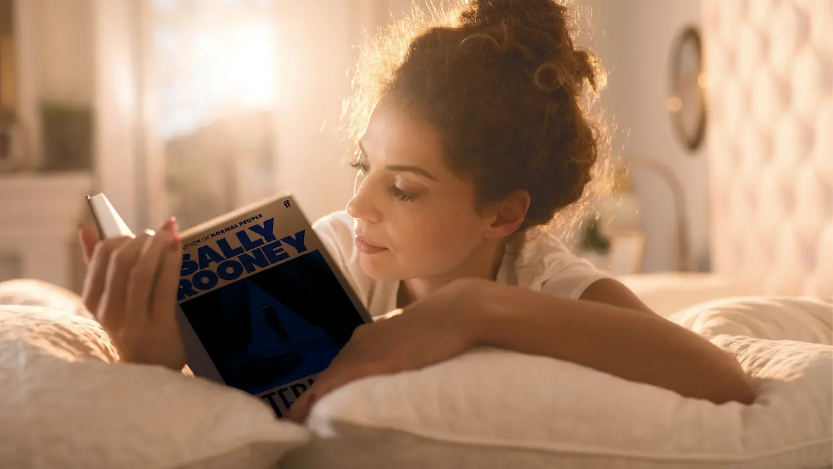 Frau liest Sally Rooneys „Intermezzo” im Bett.