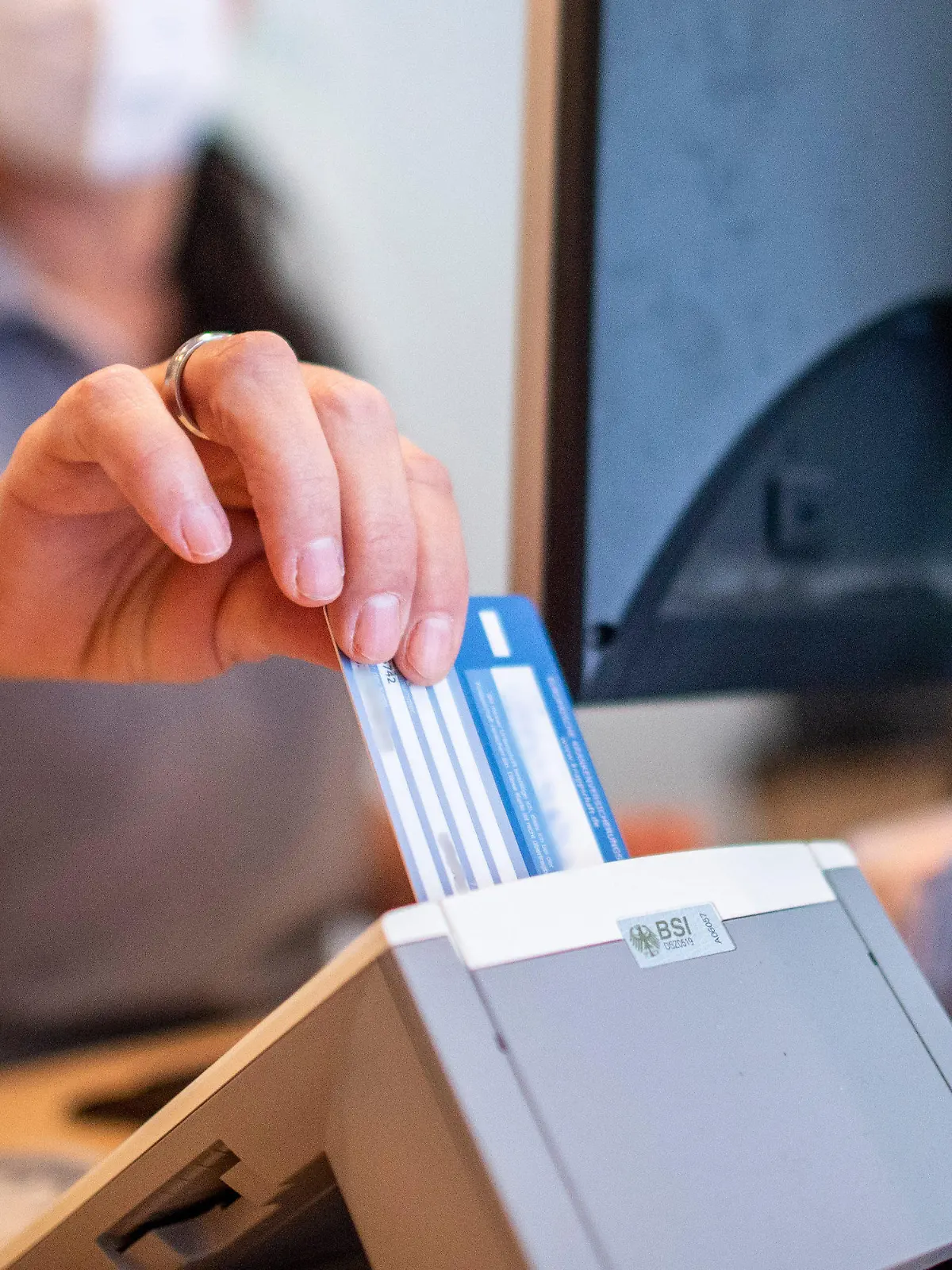 ARCHIV - 01.09.2022, Nordrhein-Westfalen, Münster: Eine Medizinische Fachangestellte schiebt in einer Hausarztpraxis die Versichertenkarte der Krankenkasse eines Patienten in das Lesegerät. Für Patientinnen und Patienten startet eine neue Möglichkeit zum Einlösen elektronischer Rezepte. Von Samstag an soll dies in ersten Apotheken mit der Versichertenkarte der Krankenkasse gehen. Versicherte müssen die Karte dafür in ein Lesegerät in der Apotheke einstecken, eine Geheimzahl wird nicht benötigt. (Illustration zu dpa "Start für neuen Einlöseweg für E-Rezepte in Apotheken") Foto: David Inderlied/dpa +++ dpa-Bildfunk +++