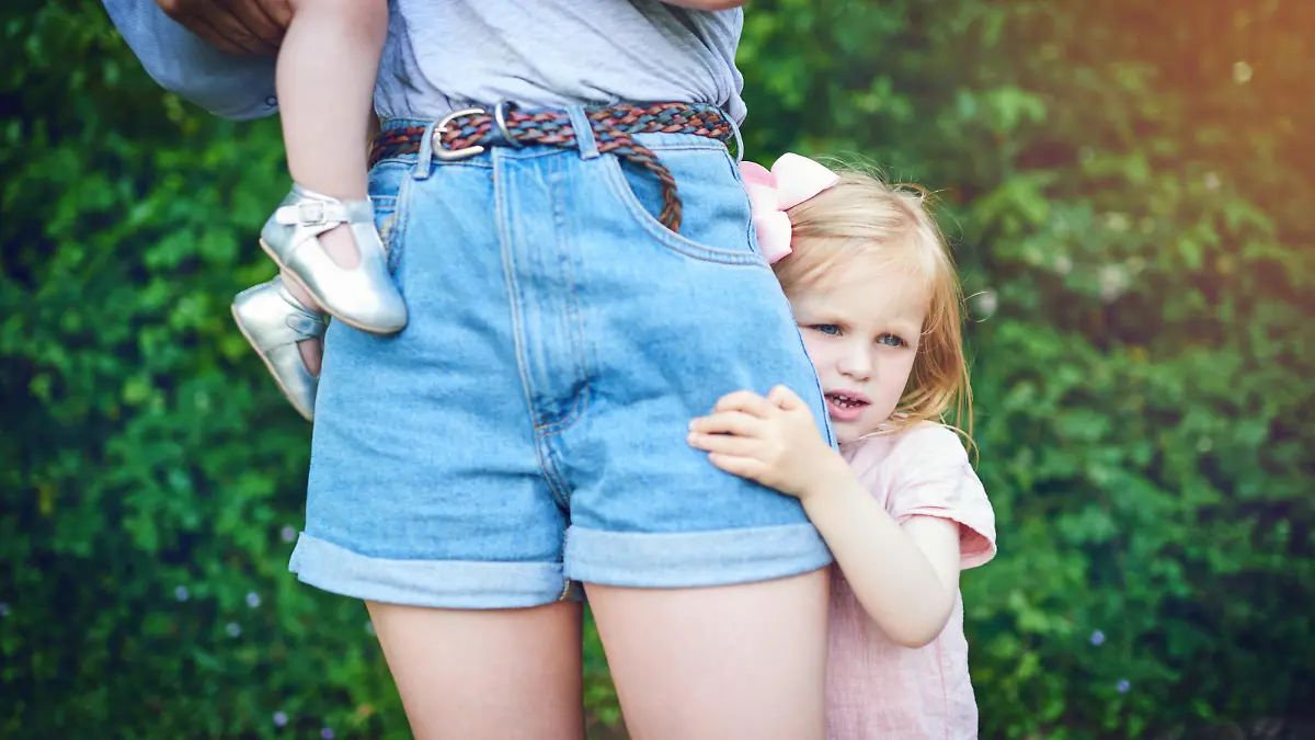 Shot of a little girl holding onto her mother during a day outdoors