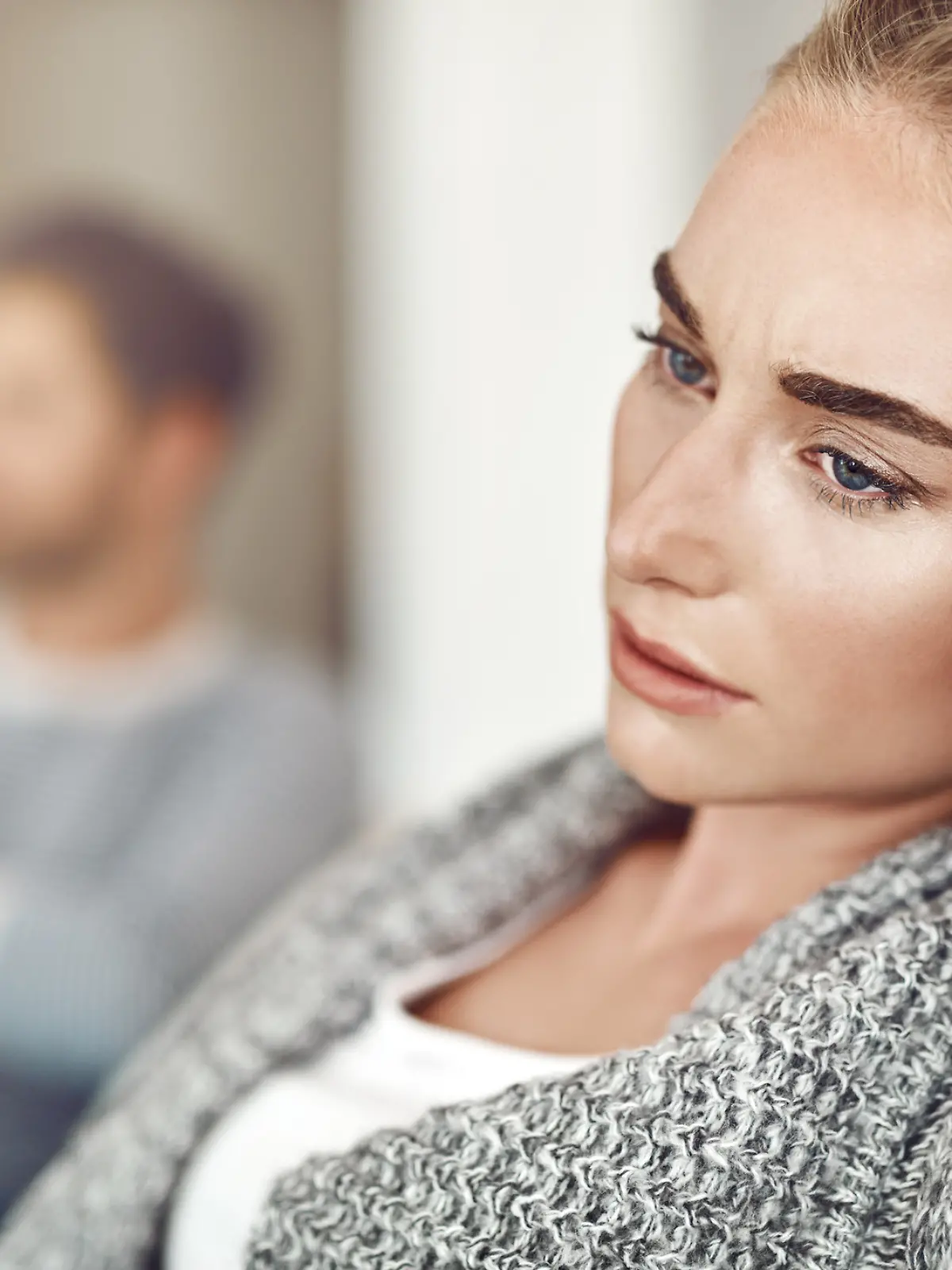 Eine Frau schaut nachdenklich in den Raum.