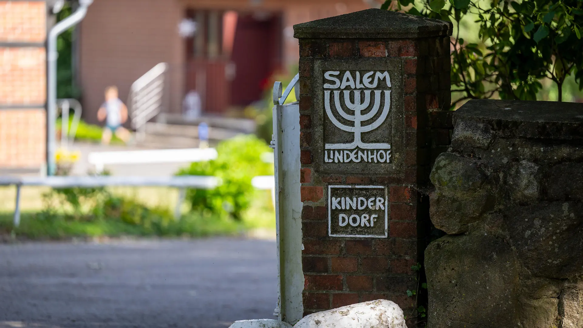 PRODUKTION - 28.06.2023, Niedersachsen, Kovahl: ·Kinderdorf· steht an der Einfahrt zum Kinder- und Jugenddorf SALEM. Nach Bekanntwerden des Missbrauchs von Schutzbefohlenen in dem Kinderdorf beginnt vor der großen Jugendkammer des Landgerichts Lüneburg am 30. Juni der Prozess gegen einen 63-jährigen Erzieher. Foto: Philipp Schulze/dpa +++ dpa-Bildfunk +++