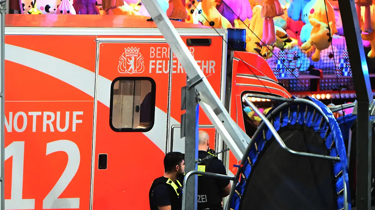 30.04.2022, Berlin: Ein Krankenwagen steht an einem Rummel am Columbiadamm. Bei einer Auseinandersetzung auf einem Berliner Rummel ist eine Person schwer verletzt worden. Im Veranstaltungsbereich der Neuköllner Maientage auf dem Columbiadamm sei es am späten Samstagabend zu der Auseinandersetzung zwischen mehreren Personen gekommen, sagte eine Polizeisprecherin. Ein dpa-Reporter berichtete, dass Schüsse gefallen seien. Der Schwerverletzte wurde in ein Krankenhaus gebracht. Foto: Paul Zinken/dpa +++ dpa-Bildfunk +++