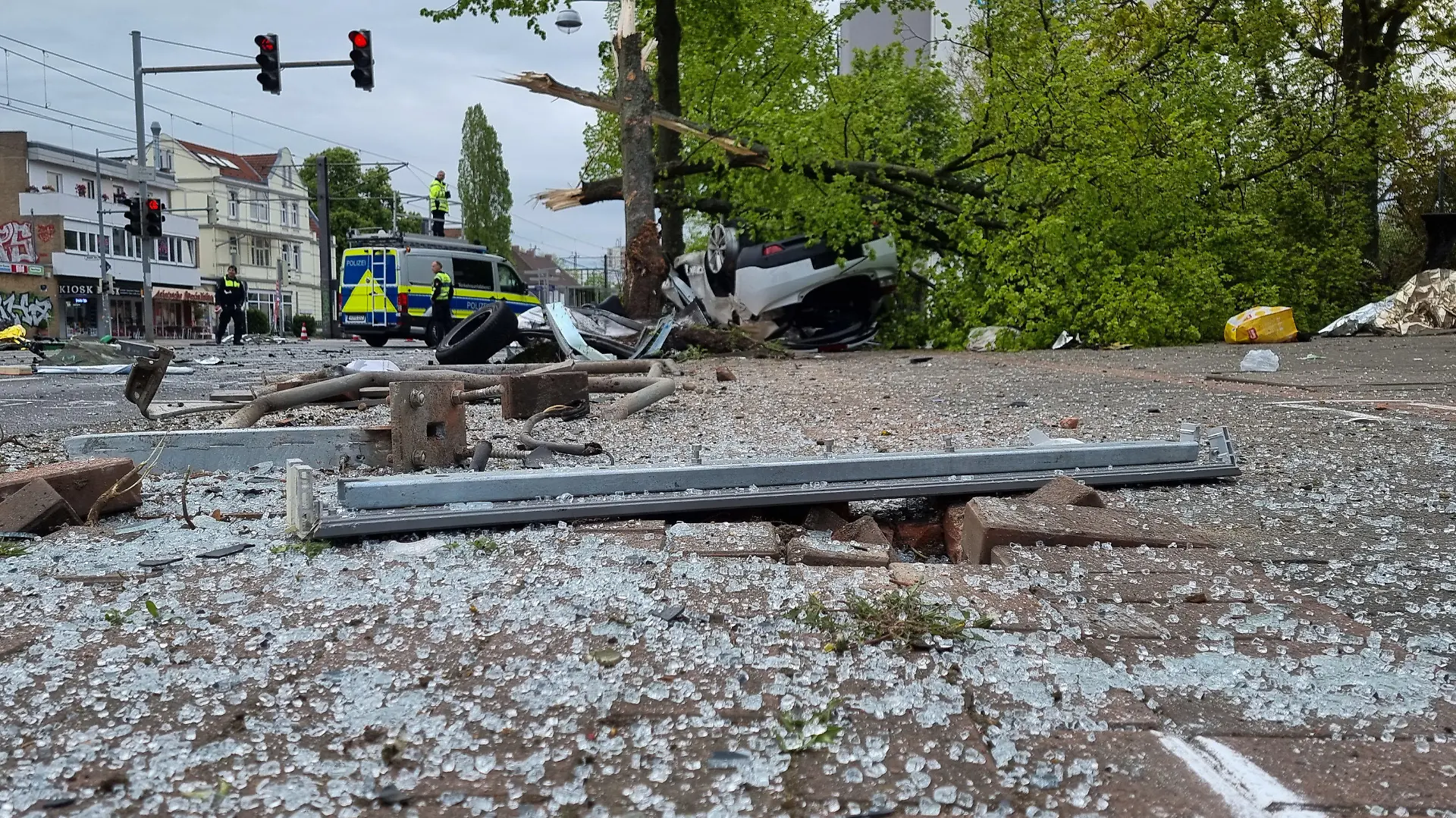 01.05.2022, Niedersachsen, Hannover: Die Straße ist mit Glassplittern übersät nach einem Unfall, der sich bei einer Verfolgungsjagd mit der Polizei ereignet hat. Dabei ist das Auto gegen einen Baum geprallt und es wurden fünf Menschen wohl schwer verletzt, wie eine Polizeisprecherin am Sonntagmorgen sagte. Demnach hatten Beamte beabsichtigt, den Wagen am frühen Morgen zu kontrollieren, woraufhin der Fahrer mit hoher Geschwindigkeit quer durch die Innenstadt davonraste. Foto: -/TNN/dpa +++ dpa-Bildfunk +++
