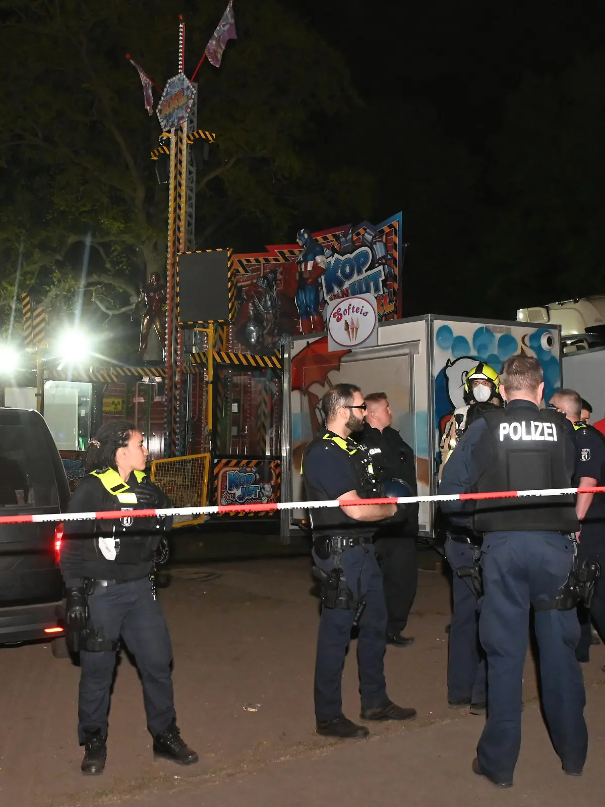 01.05.2022, Berlin: Polizeibeamte stehen auf dem Gelände eines Rummels am Columbiadamm.Bei einer Auseinandersetzung auf einem Berliner Rummel ist eine Person schwer verletzt worden. Im Veranstaltungsbereich der Neuköllner Maientage auf dem Columbiadamm sei es am späten Samstagabend zu der Auseinandersetzung zwischen mehreren Personen gekommen, sagte eine Polizeisprecherin. Ein dpa-Reporter berichtete, dass Schüsse gefallen seien. Der Schwerverletzte wurde in ein Krankenhaus gebracht. Foto: Paul Zinken/dpa +++ dpa-Bildfunk +++