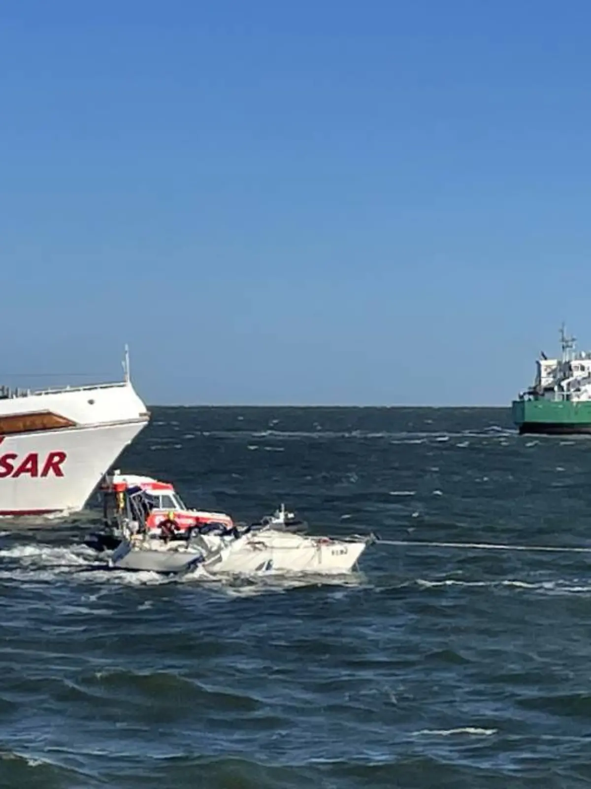 Das Segelboot (Bildmitte) kollidierte mit dem Frachtschiff Lotta (rechts). Der Seenotrettungskreuzer Anneliese Kramer rettete den Skipper der verunglückten Jacht.