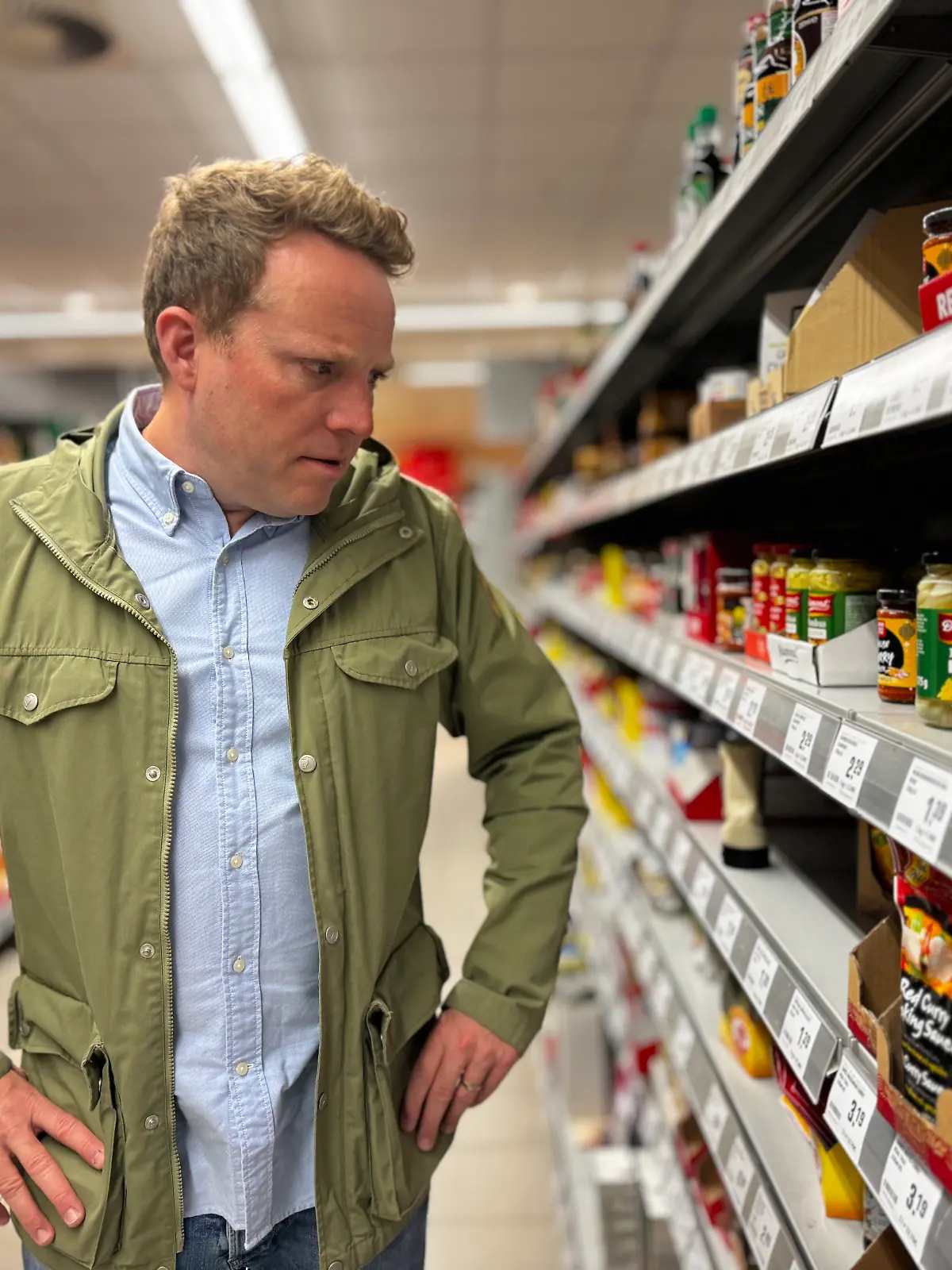 Mann steht vor Supermarktregal 