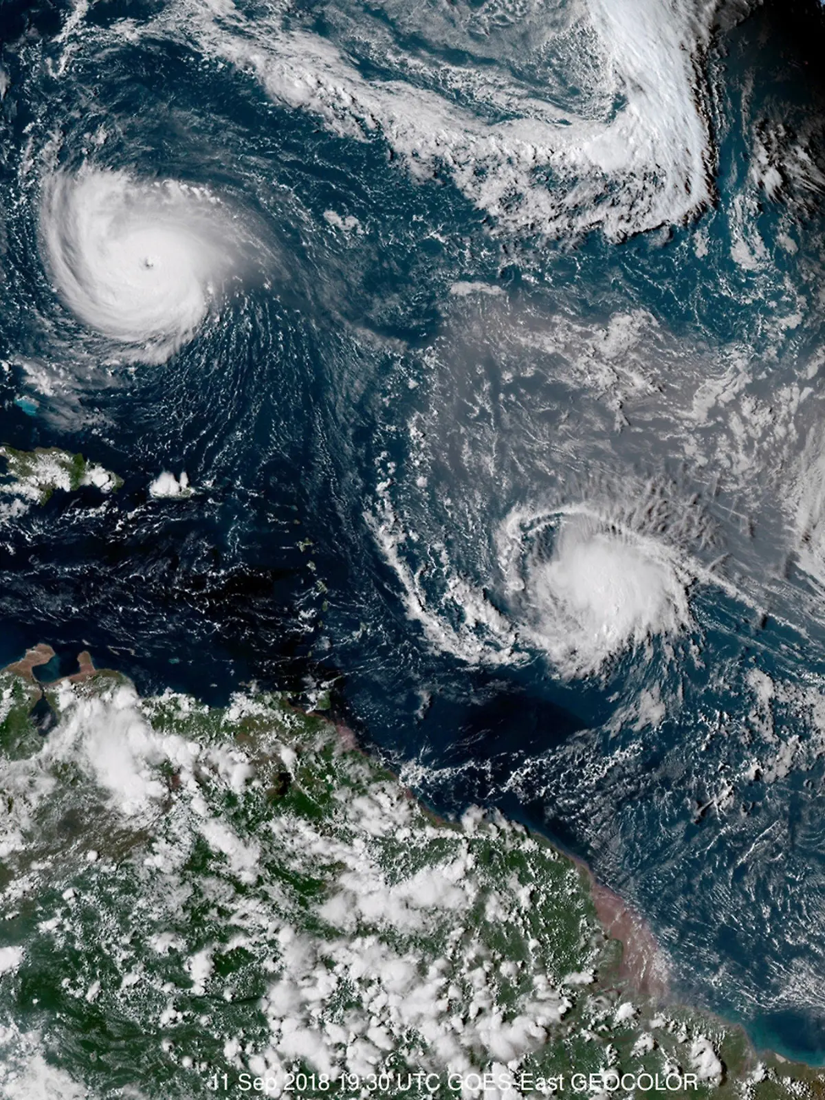 FILE - This enhanced satellite image made available by NOAA shows Tropical Storm Florence, upper left, in the Atlantic Ocean on Tuesday, Sept. 11, 2018 at 3:30 p.m. EDT. At center is Tropical Storm Isaac and at right is Hurricane Helene. According to a study released on Wednesday, Nov. 11, 2020, hurricanes are keeping their staying power longer once they make landfall, spreading more inland destruction. (NOAA via AP)