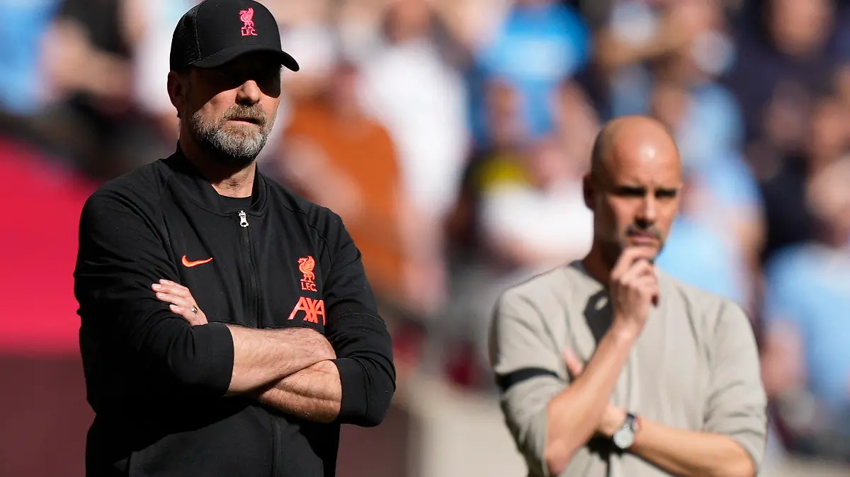 Liverpool's manager Jurgen Klopp, left, and Manchester City's head coach Pep Guardiola stand on the touchline during the English FA Cup semifinal soccer match between Manchester City and Liverpool at Wembley stadium in London, Saturday, April 16, 2022. (AP Photo/Frank Augstein)
